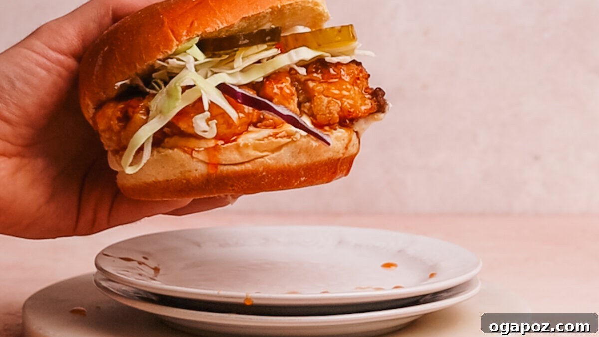 Crispy Sweet Heat Chicken Sandwich 10 A hand picking up the finished hot honey chicken sandwich, ready to eat.