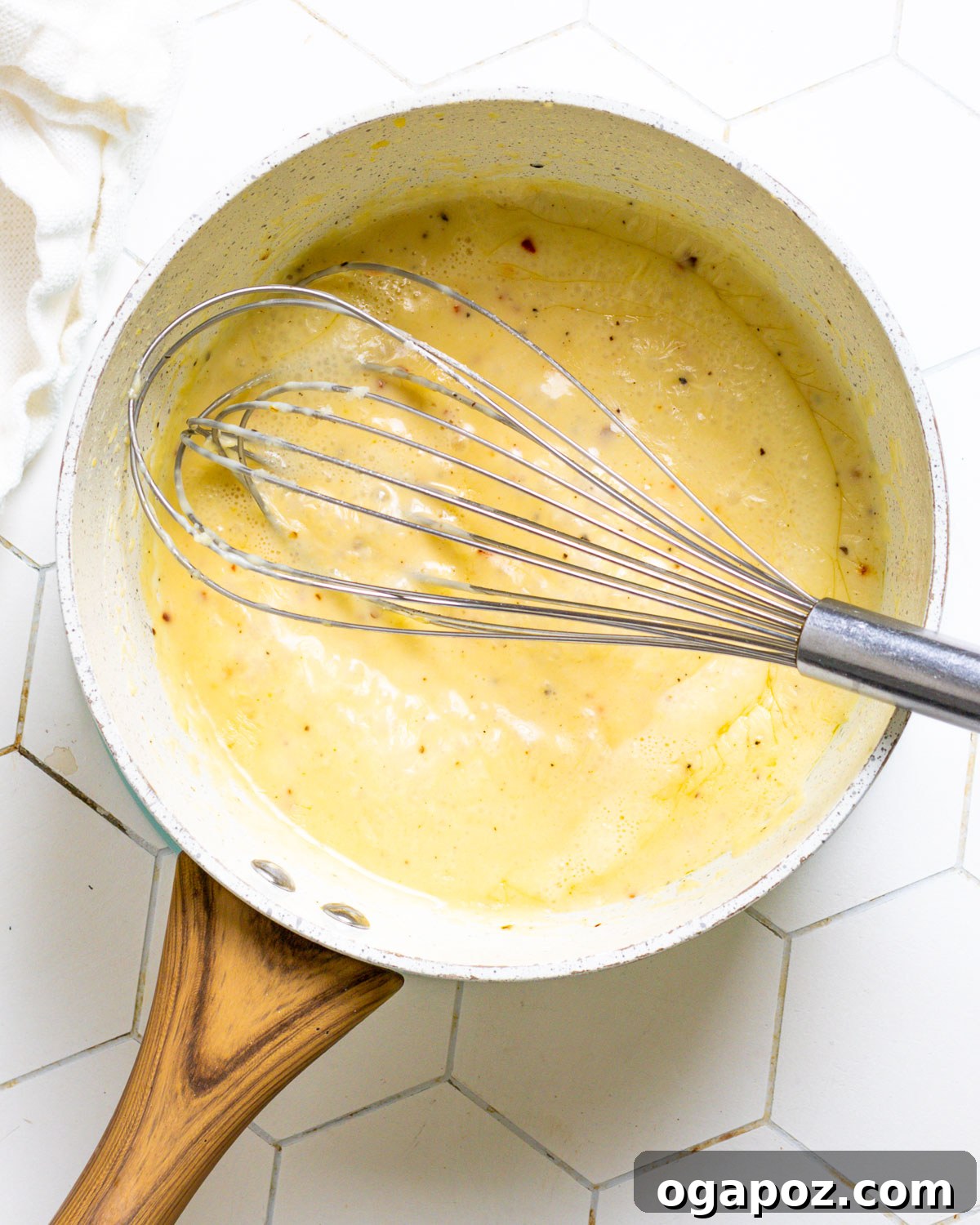 Signature Garlic Parmesan Wings 7 Whisking garlic parmesan sauce in a saucepan