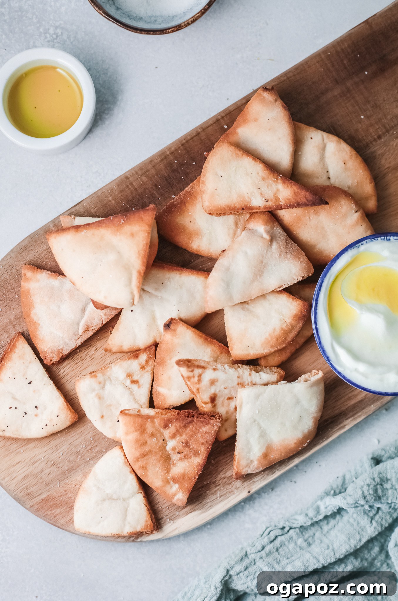 Crispy Air Fryer Pita Chips 2 Golden brown Air Fryer Pita Chips on a rustic wooden board, ready to be enjoyed.