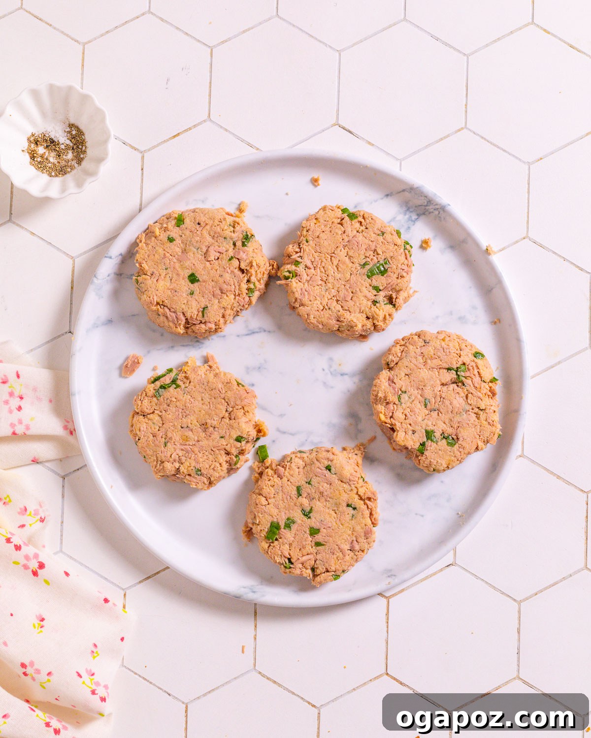 Shaped tuna patties ready for cooking on a plate