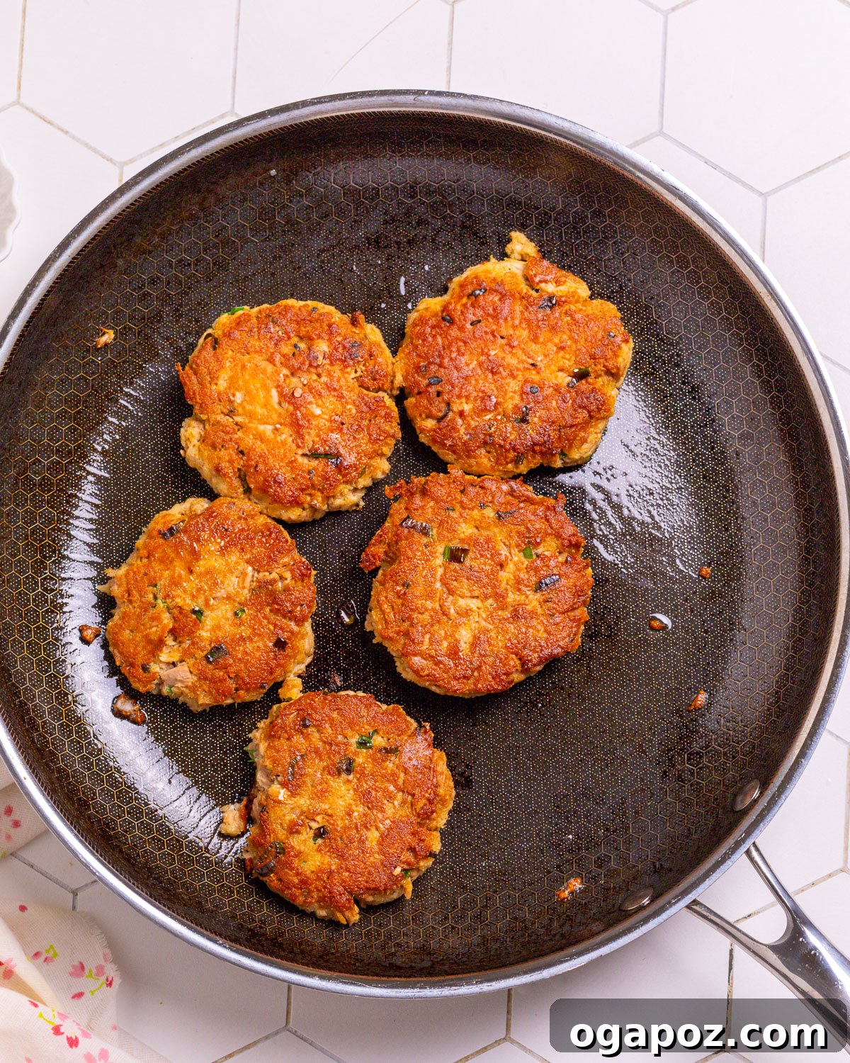 Tuna patties cooking in a hot skillet