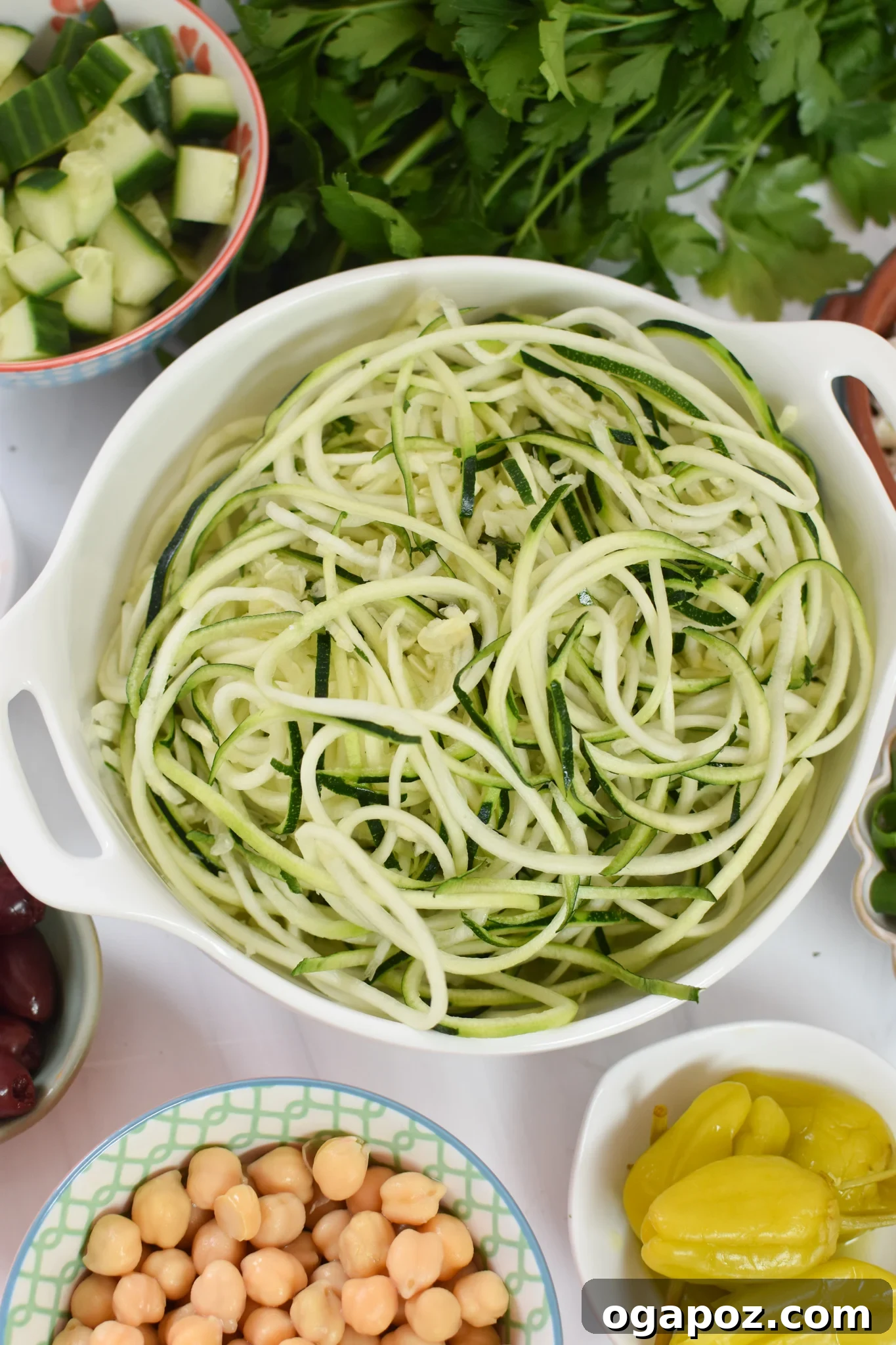 Vibrant Mediterranean Zucchini Pasta Salad 5 Close-up of spiralized zucchini noodles being drained on paper towels, demonstrating the moisture removal process.