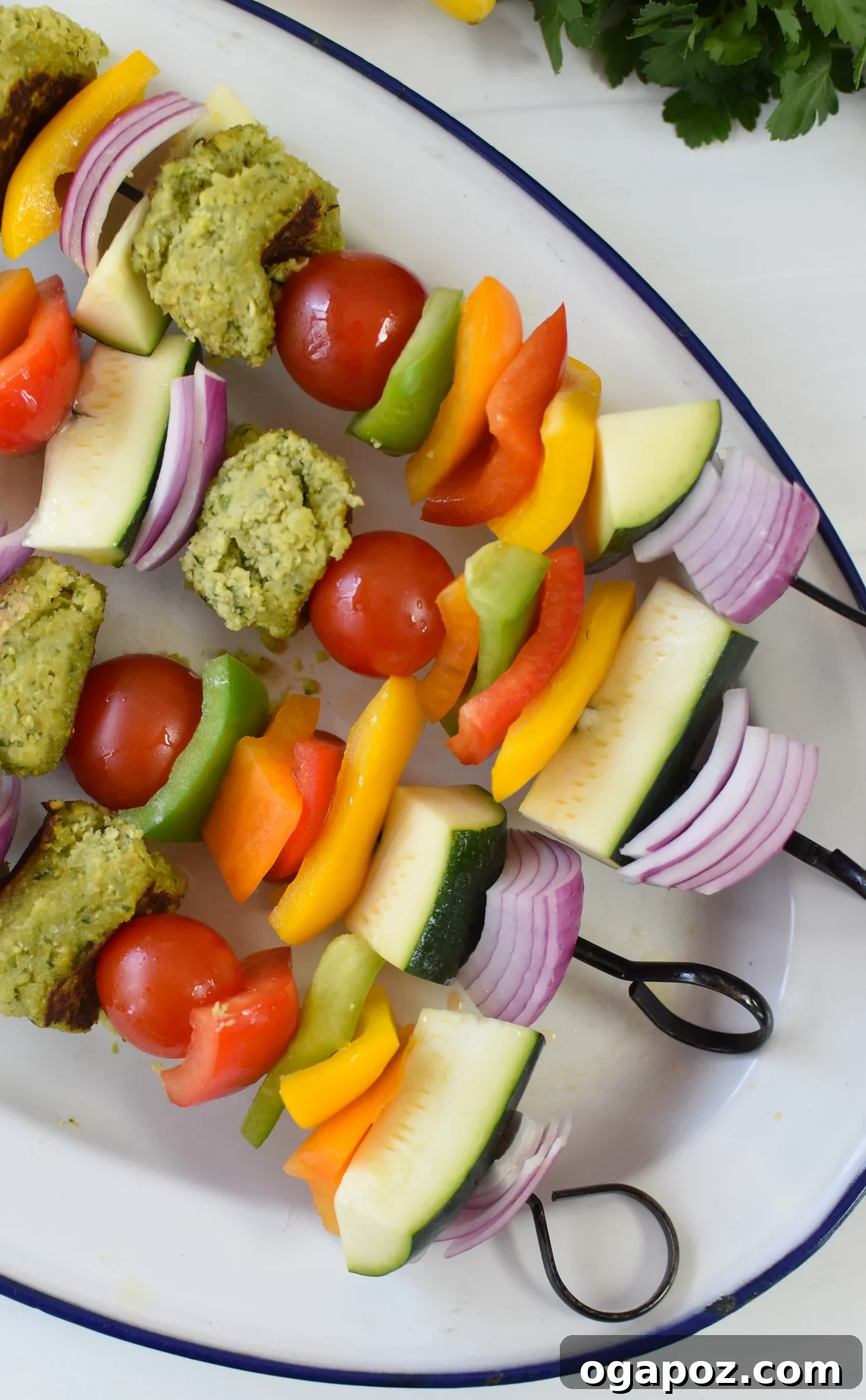 Mediterranean Falafel & Veggie Skewers 7 Assembled Falafel Vegetable Kabobs arranged on a platter, showcasing the alternating pattern of falafel balls, bell peppers, zucchini, onion, and cherry tomatoes on skewers.
