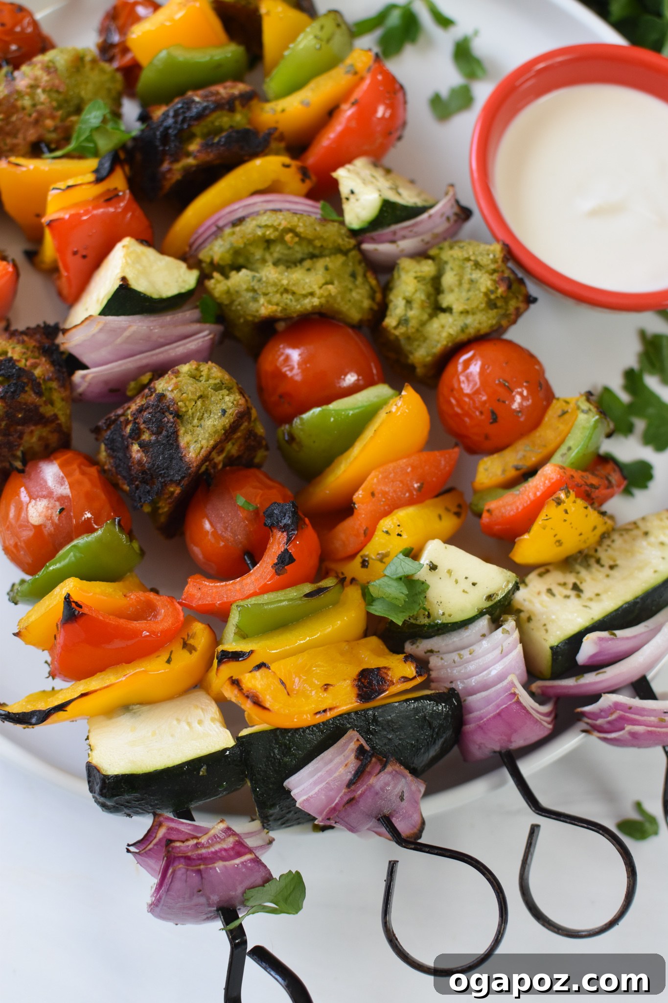 Mediterranean Falafel & Veggie Skewers 10 Close-up of grilled Falafel Vegetable Kabobs drizzled generously with creamy tahini sauce, garnished with fresh parsley.