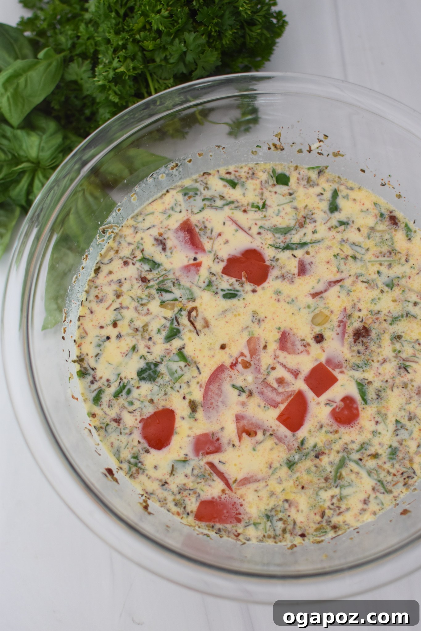 Italian Summer Quiche Lorraine 7 A bowl of egg mixture with chopped onions, cheese, bacon, diced tomatoes, basil, and parsley stirred in.