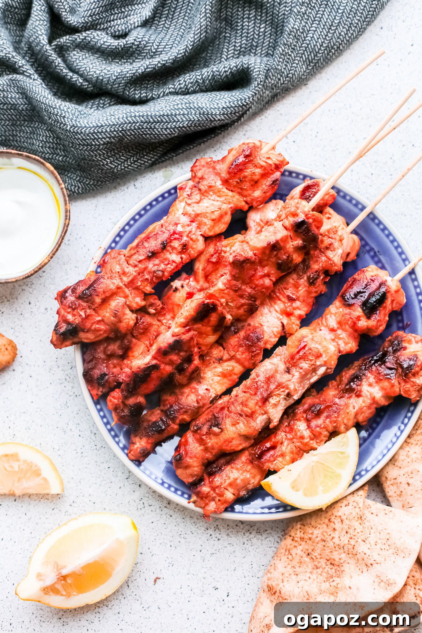 Marinated Lebanese Chicken Skewers 2 Lebanese Chicken Kebabs on a blue plate.