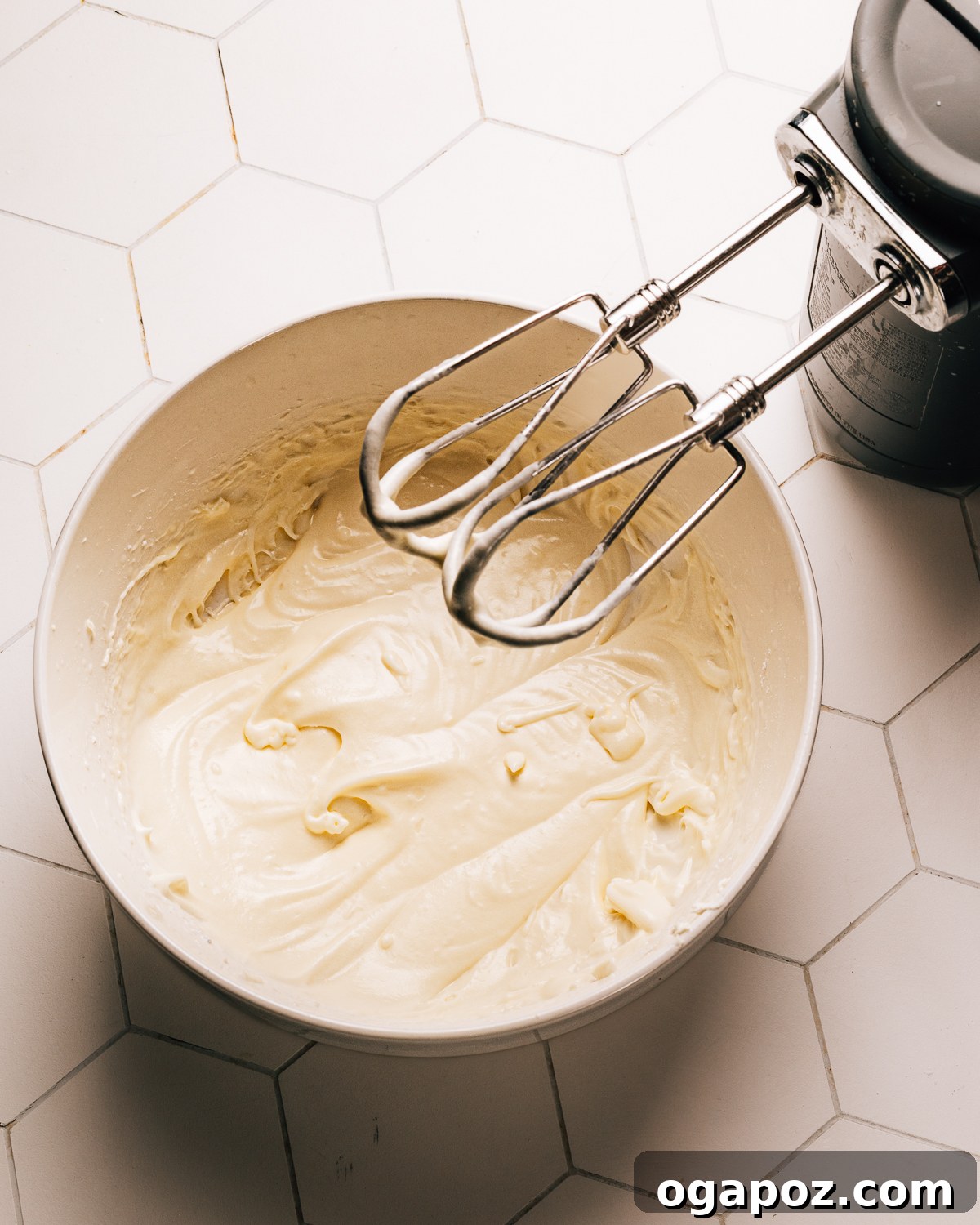 Perfect Cream Cheese Frosting 6 Thinned out cream cheese frosting drizzling from a spoon.