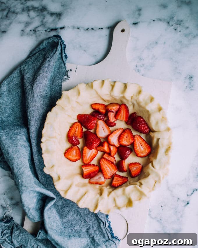 Sunshine Strawberry Buttermilk Pie 3 A whole strawberry buttermilk pie cooling on a wire rack, with a golden-brown crust and glistening fruit filling.