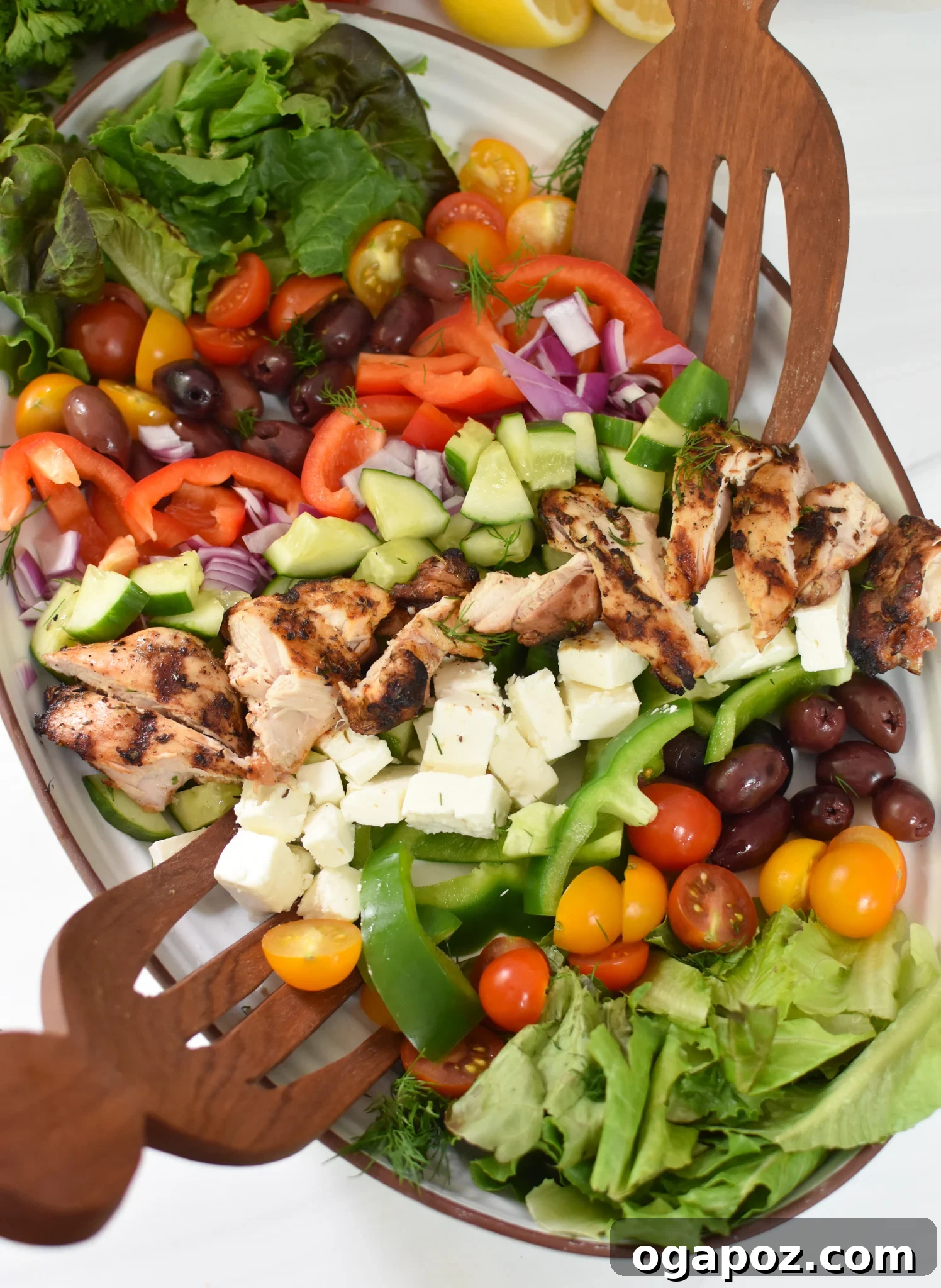 A large platter generously filled with colorful Grilled Chicken Greek Salad, ready to serve.