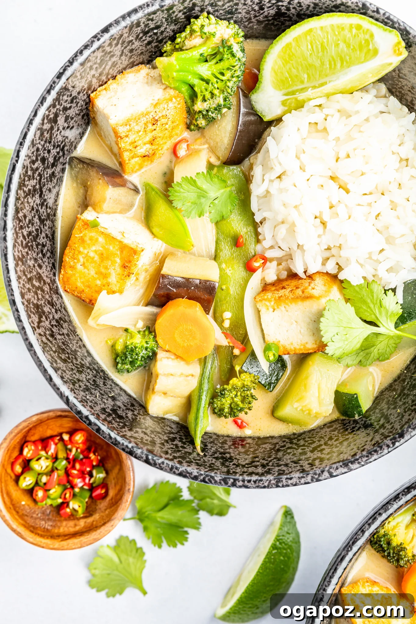 Quick & Delicious Thai Veggie Green Curry 2 A vibrant bowl of Thai Vegetable Green Curry, garnished with fresh cilantro and crunchy peanuts, ready to be served.