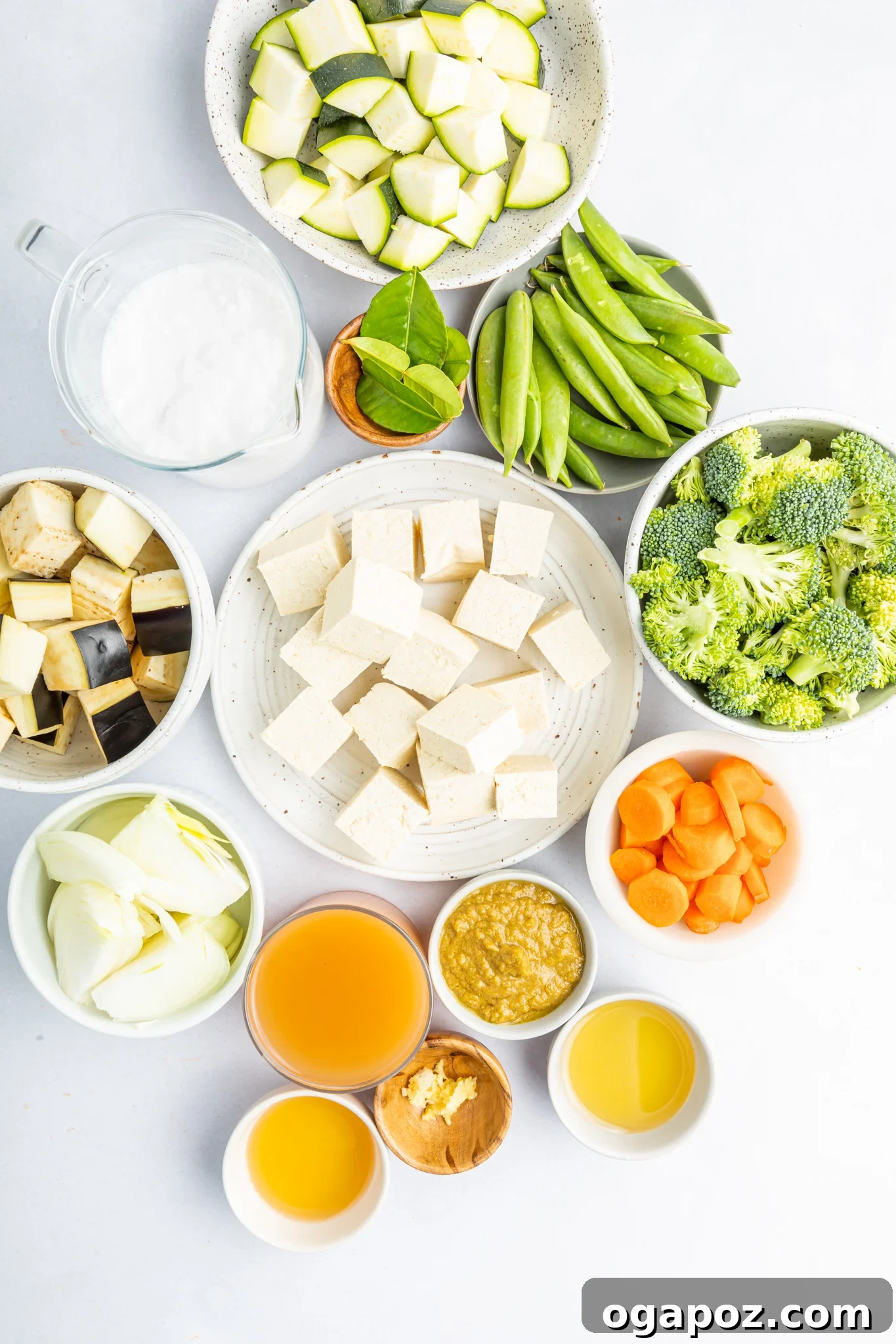 Quick & Delicious Thai Veggie Green Curry 3 A vibrant selection of fresh ingredients laid out for making Thai Vegetable Green Curry, including tofu, green curry paste, an assortment of colorful vegetables, and aromatic lime leaves.