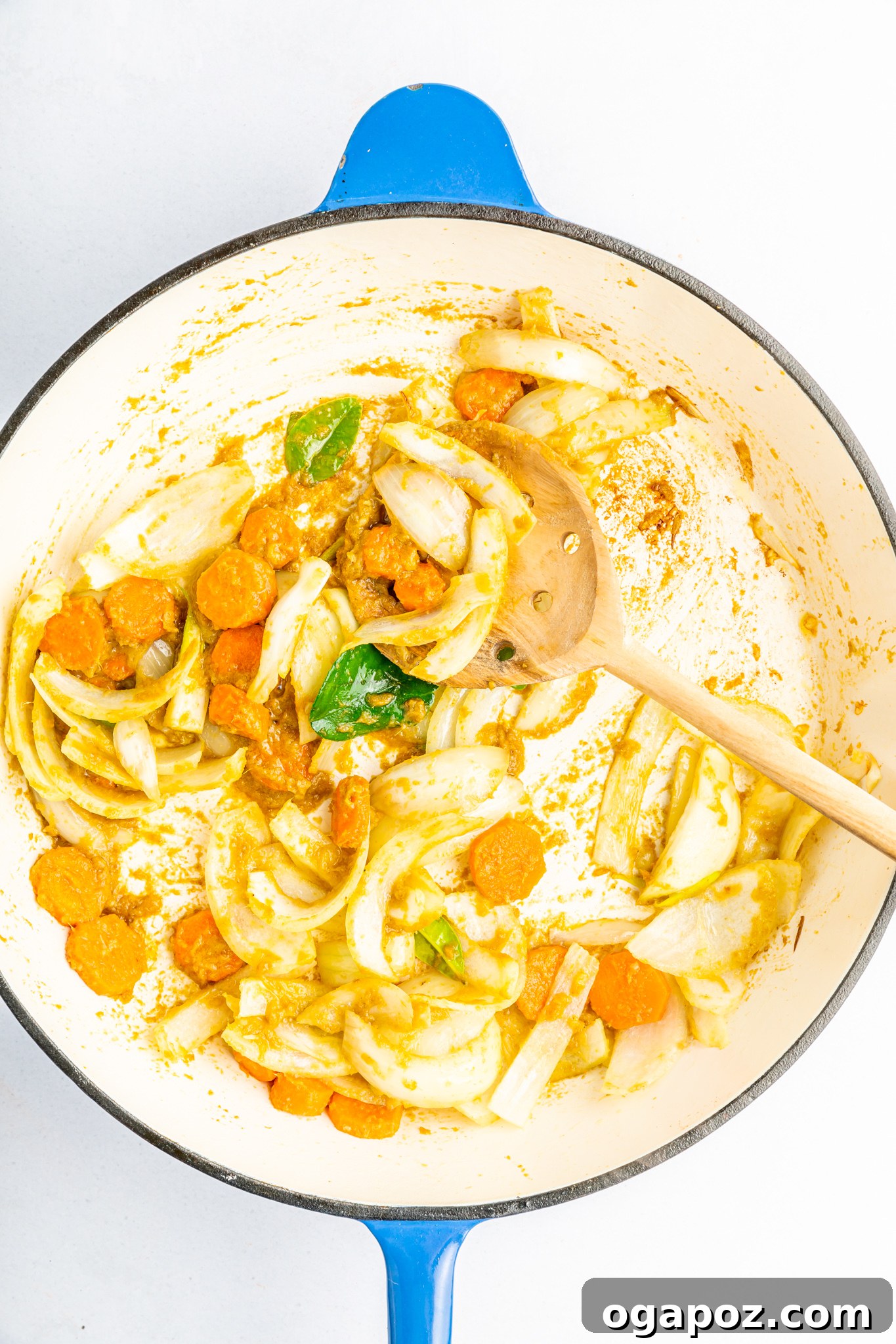 Quick & Delicious Thai Veggie Green Curry 5 Sliced onions, minced garlic, and thinly sliced carrots gently sautéing in a hot skillet, becoming translucent and fragrant, marking the initial stage of building the Thai Vegetable Green Curry's flavor base.