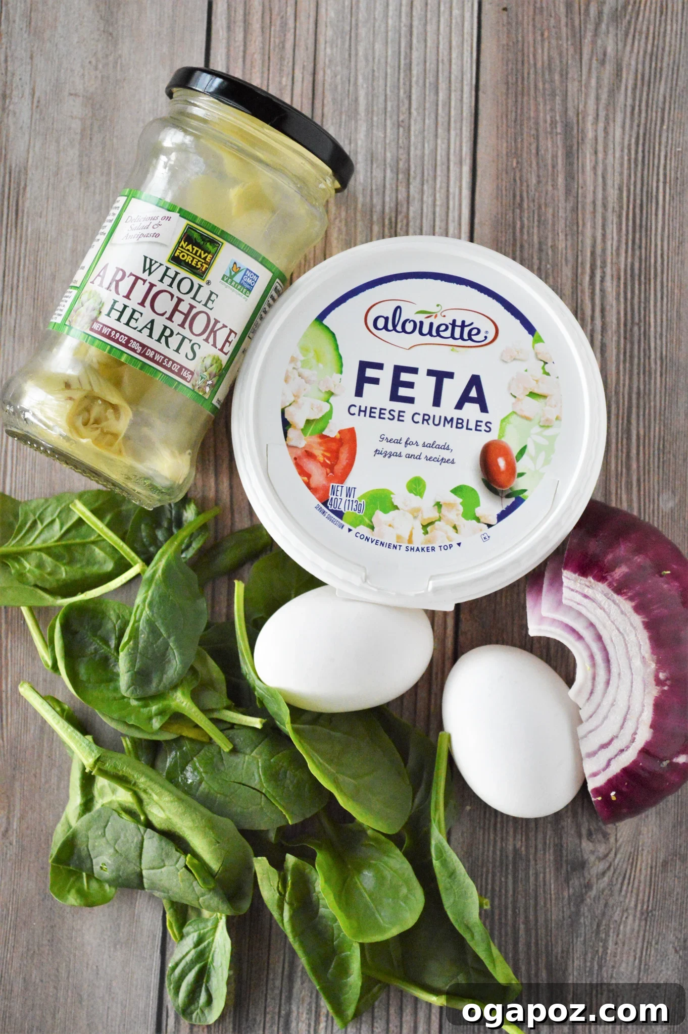 Rustic Greek Egg Bake 3 Fresh ingredients laid out for Greek Baked Eggs: eggs, red onion, spinach, artichoke hearts, and feta cheese.