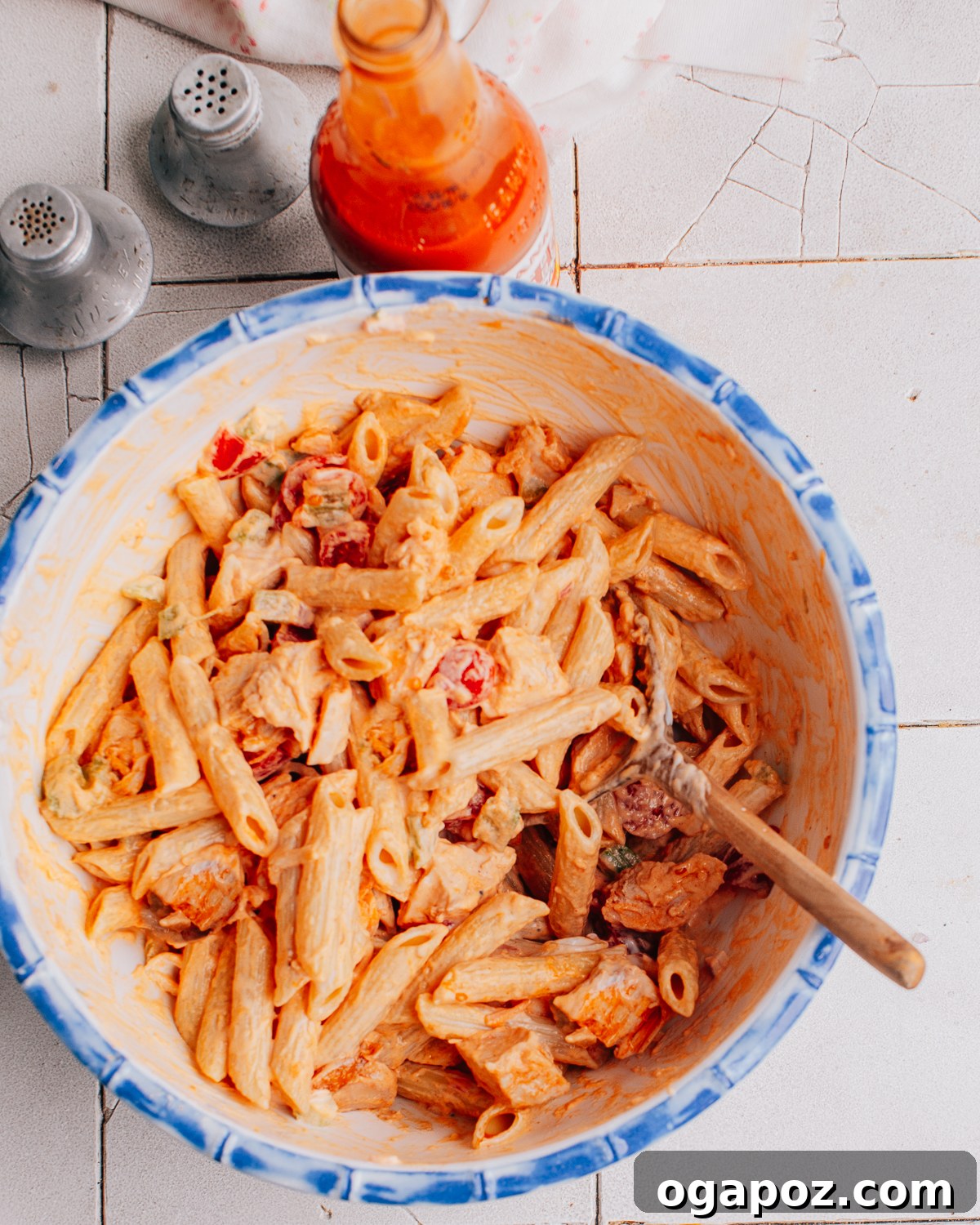 Buffalo Chicken Pasta Salad recipe in a bowl, garnished with fresh herbs.