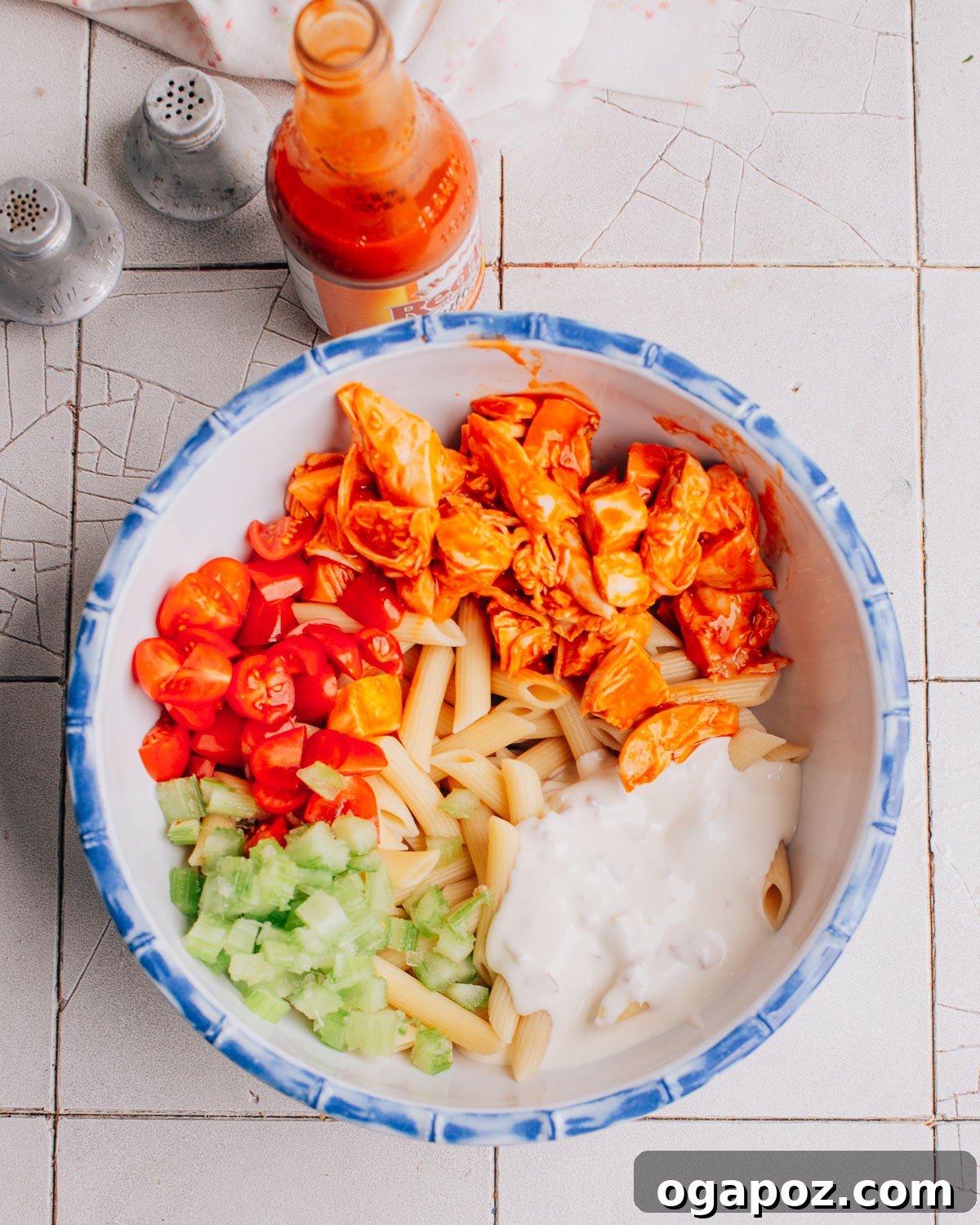 Buffalo Chicken Pasta Salad ingredients being mixed in a large bowl.
