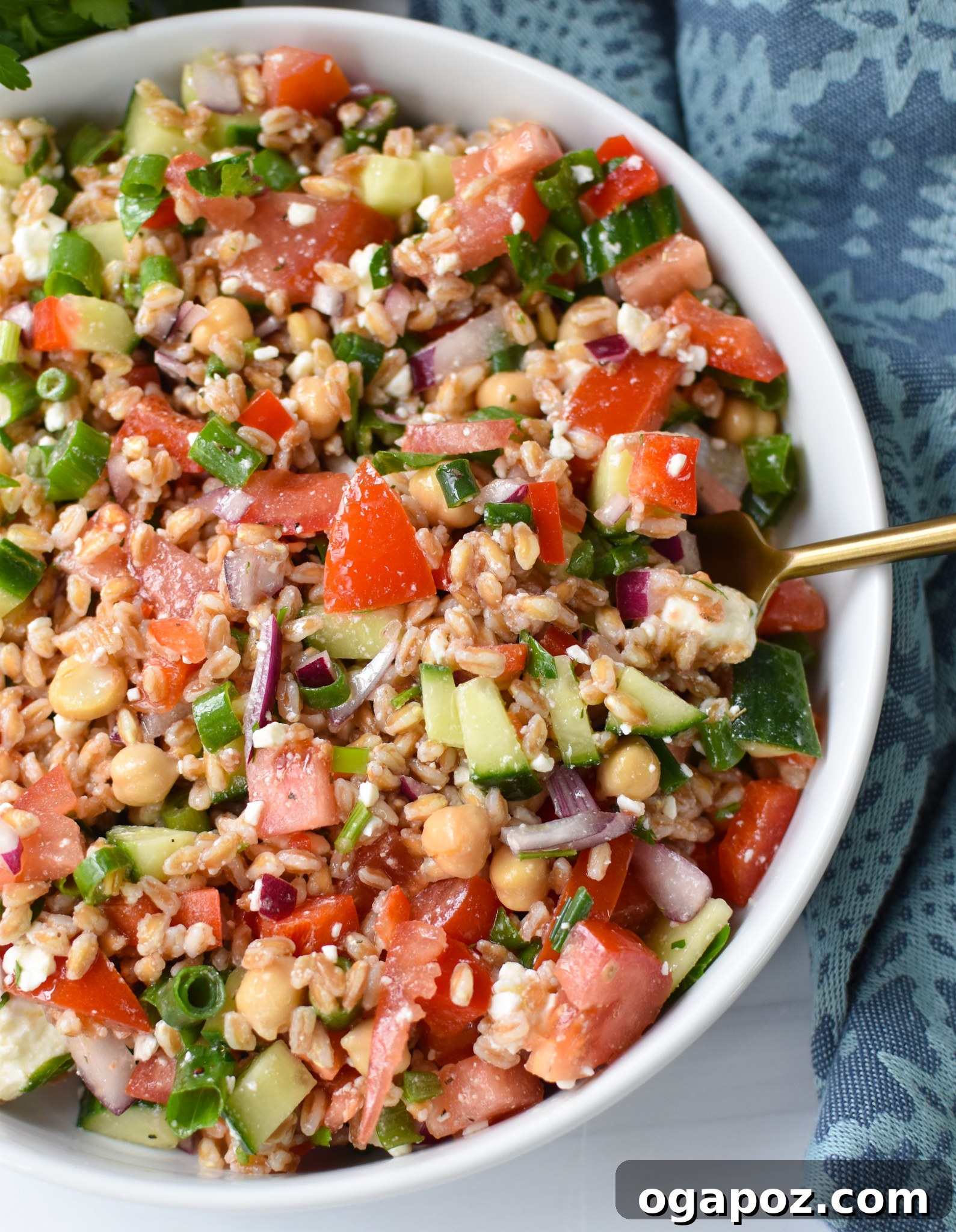 Siyezli Akdeniz Salatası 4 A close-up of Mediterranean Farro Salad with a golden spoon, ready to be served.