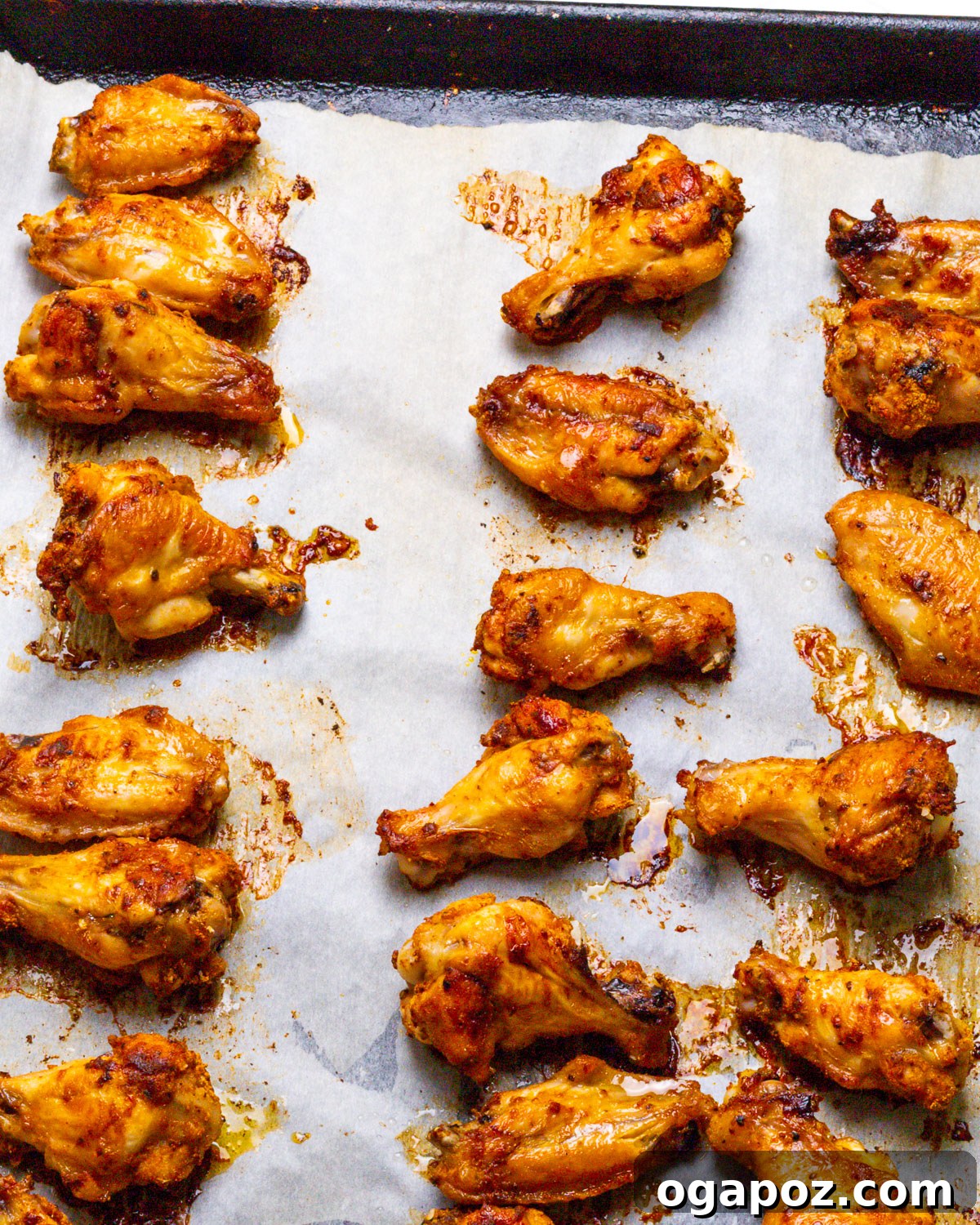 Hot Honey Glazed Crispy Wings 4 Baked chicken wings arranged on a baking sheet, golden and crispy