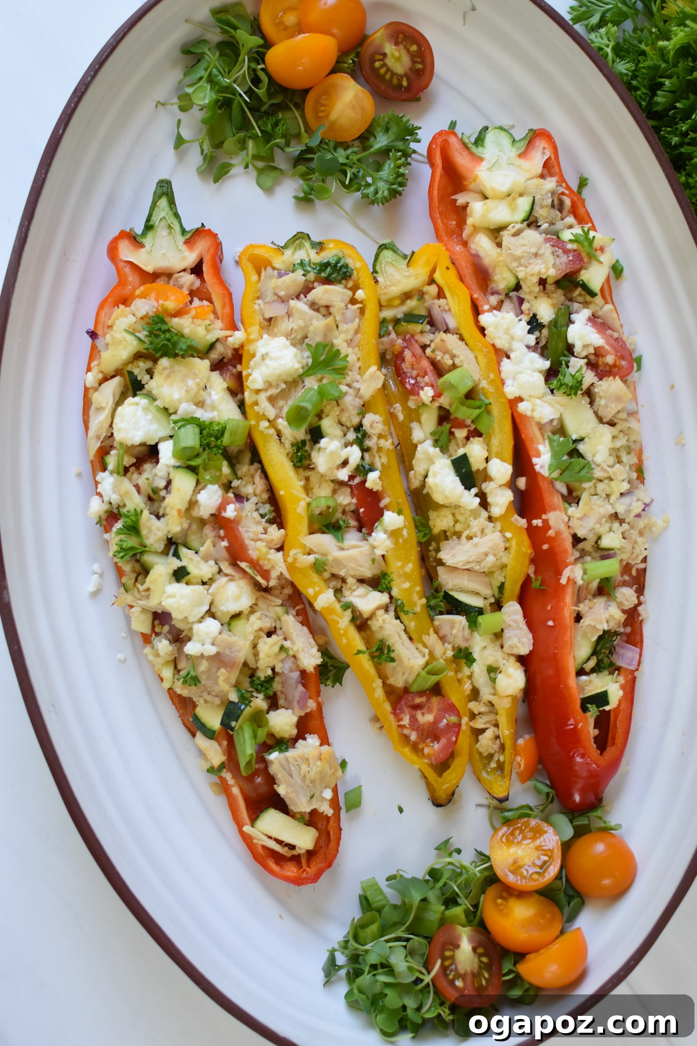 Sun-Kissed Mediterranean Tuna Couscous Peppers 2 Mediterranean Tuna Couscous Stuffed Peppers on a white platter, showcasing vibrant colors and fresh ingredients.