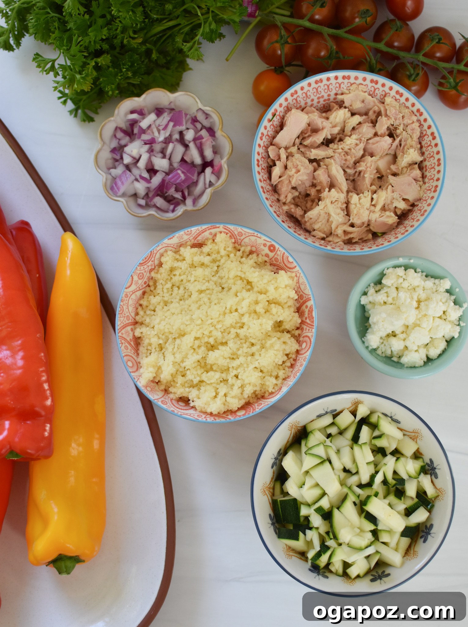 Sun-Kissed Mediterranean Tuna Couscous Peppers 4 All the fresh ingredients for Mediterranean Tuna Couscous Stuffed Peppers laid out on a cutting board, including tuna, couscous, peppers, vegetables, and herbs.