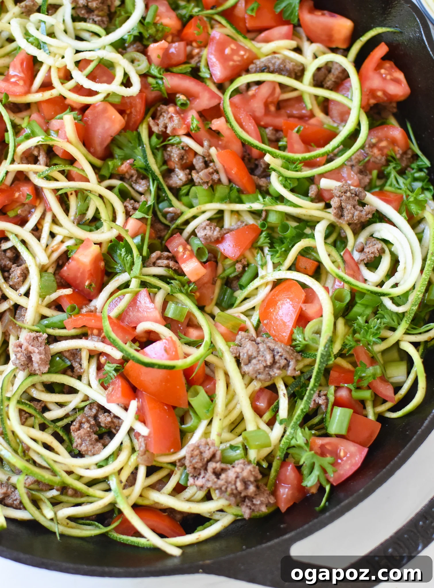 Vibrant Mediterranean Beef and Zucchini Skillet 9 Mediterranean Ground Beef Zucchini Skillet topped with fresh tomatoes and herbs.