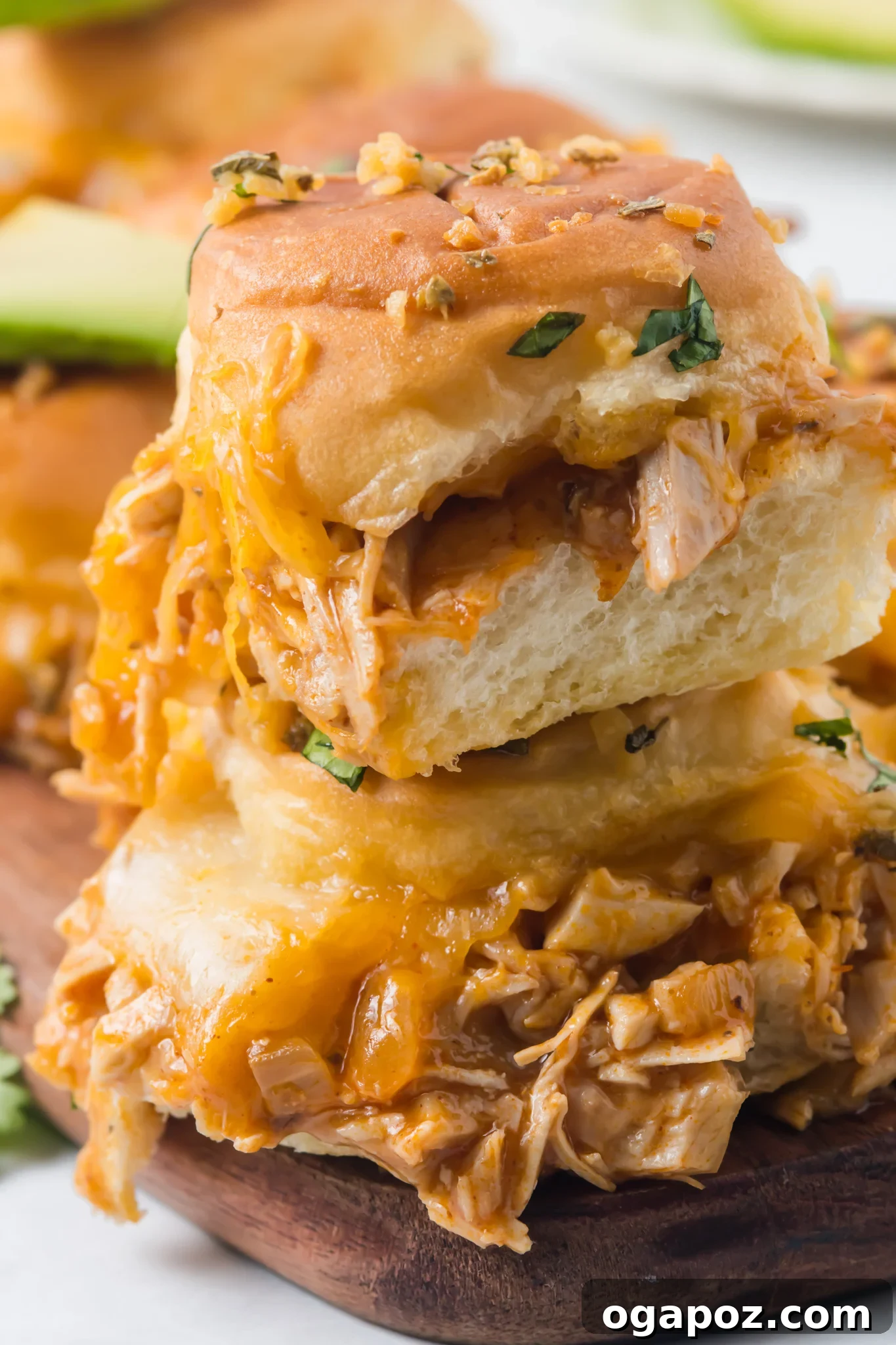 Pull-Apart Chicken Enchilada Sliders 2 Golden brown Chicken Enchilada Sliders topped with melted cheese and fresh herbs, ready to be served.