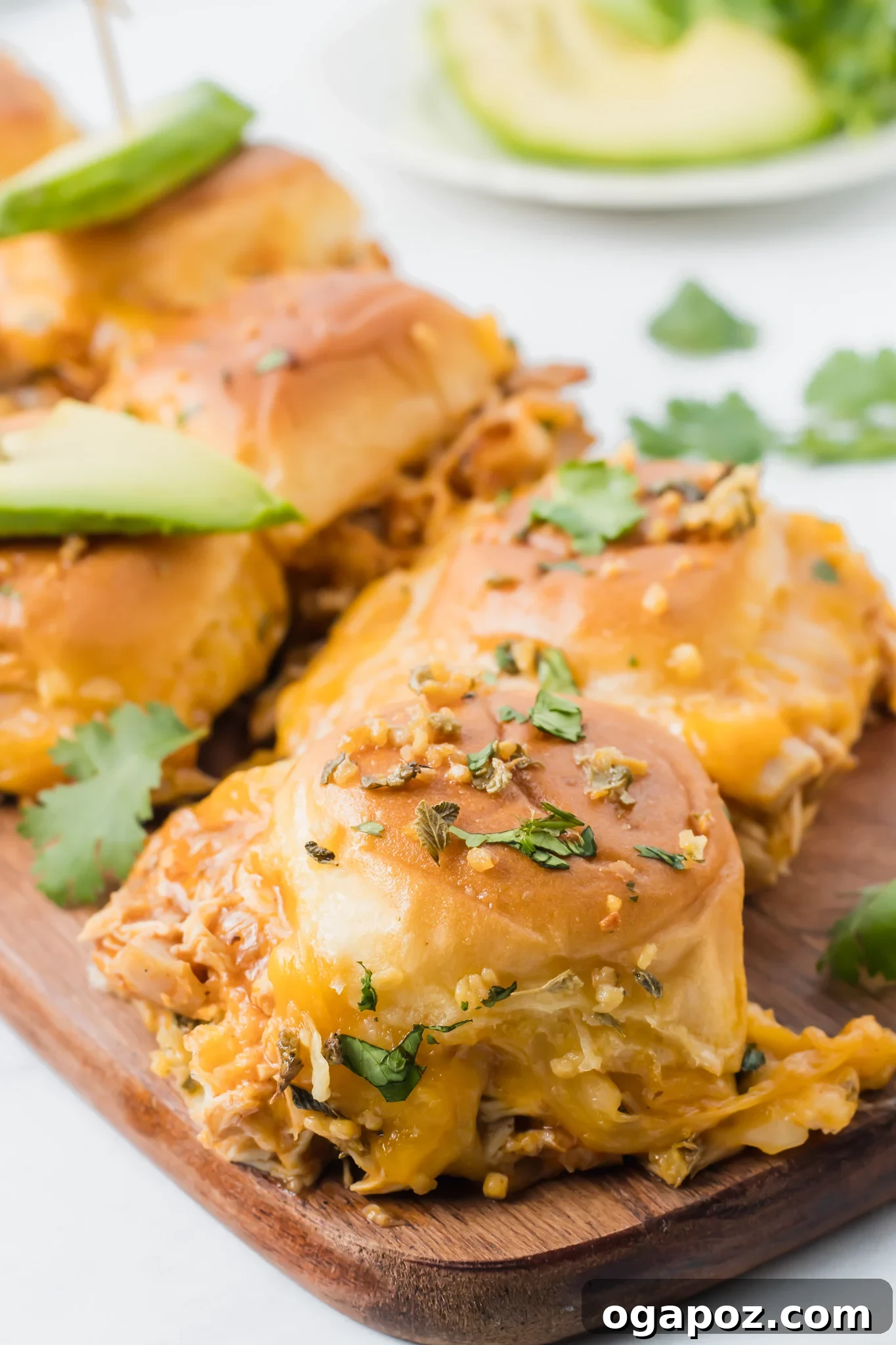 Pull-Apart Chicken Enchilada Sliders 4 Close-up of baked Chicken Enchilada Sliders with Mexican oregano sprinkled on top of the golden-brown buns.