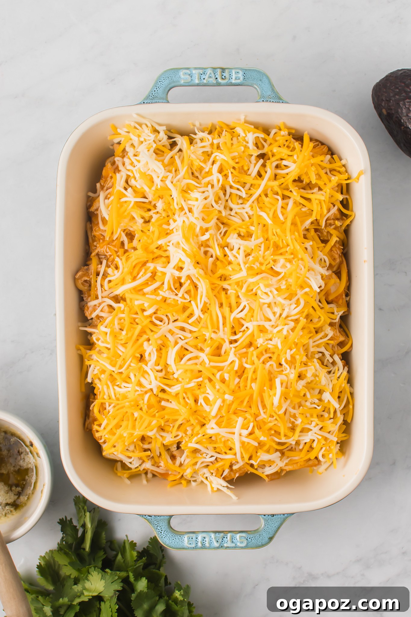 Pull-Apart Chicken Enchilada Sliders 9 A generous layer of shredded cheese covering the chicken enchilada mixture on the slider buns.