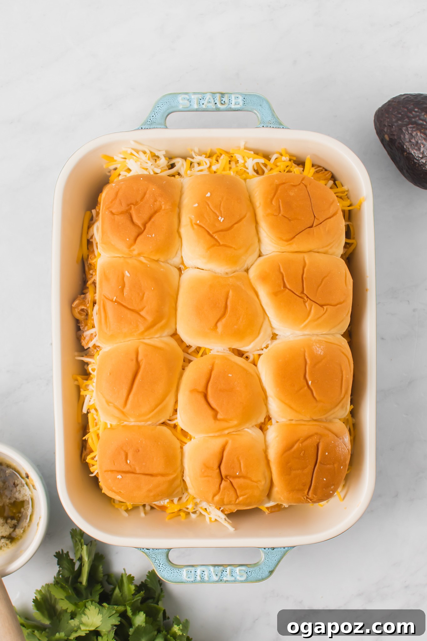 Pull-Apart Chicken Enchilada Sliders 10 Assembled Chicken Enchilada Sliders in a baking pan, with the top buns placed over the cheesy chicken filling.