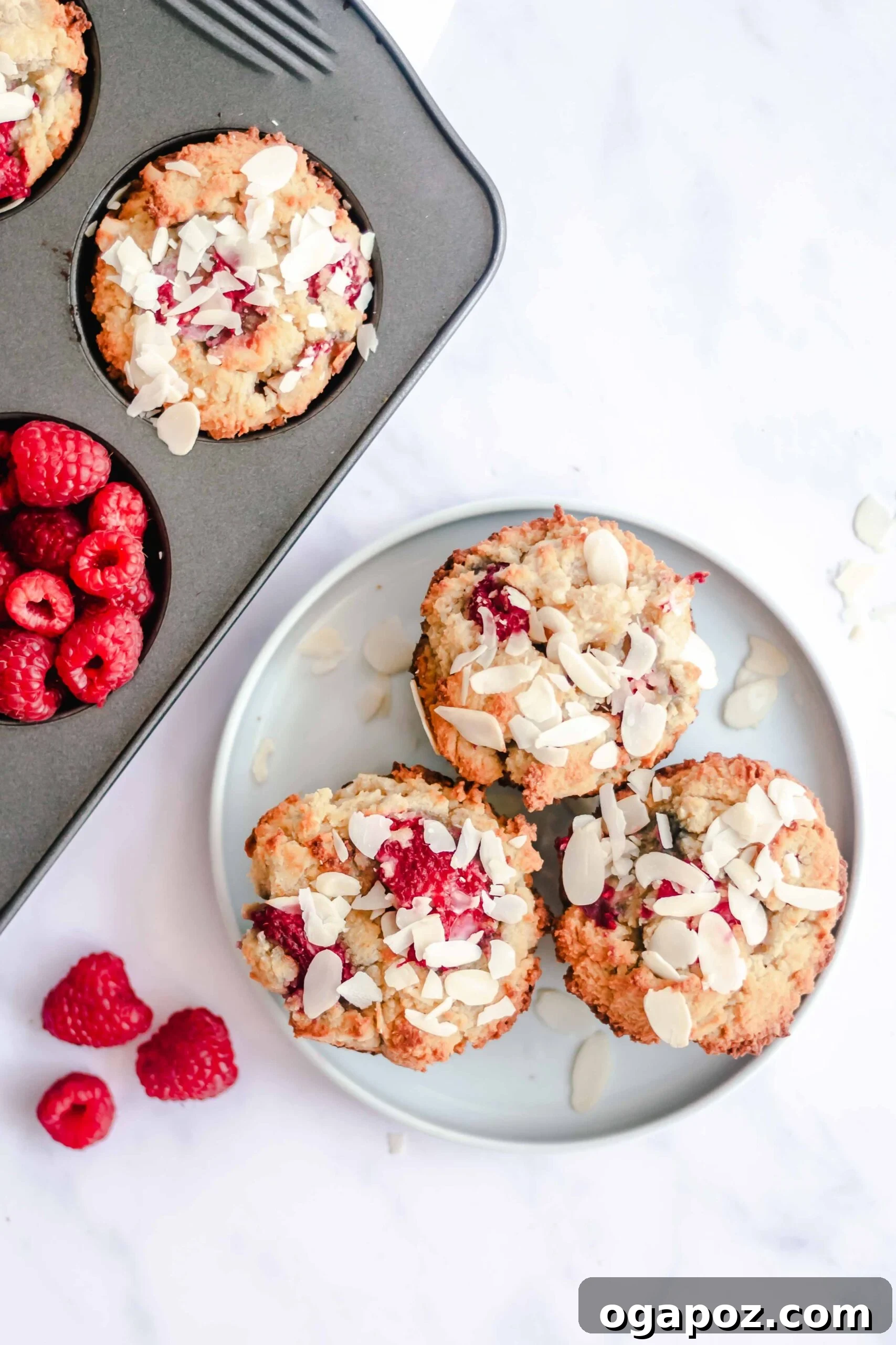Delightful Keto Raspberry Muffins 3 Plated Keto Raspberry Muffins with fresh raspberries on top.
