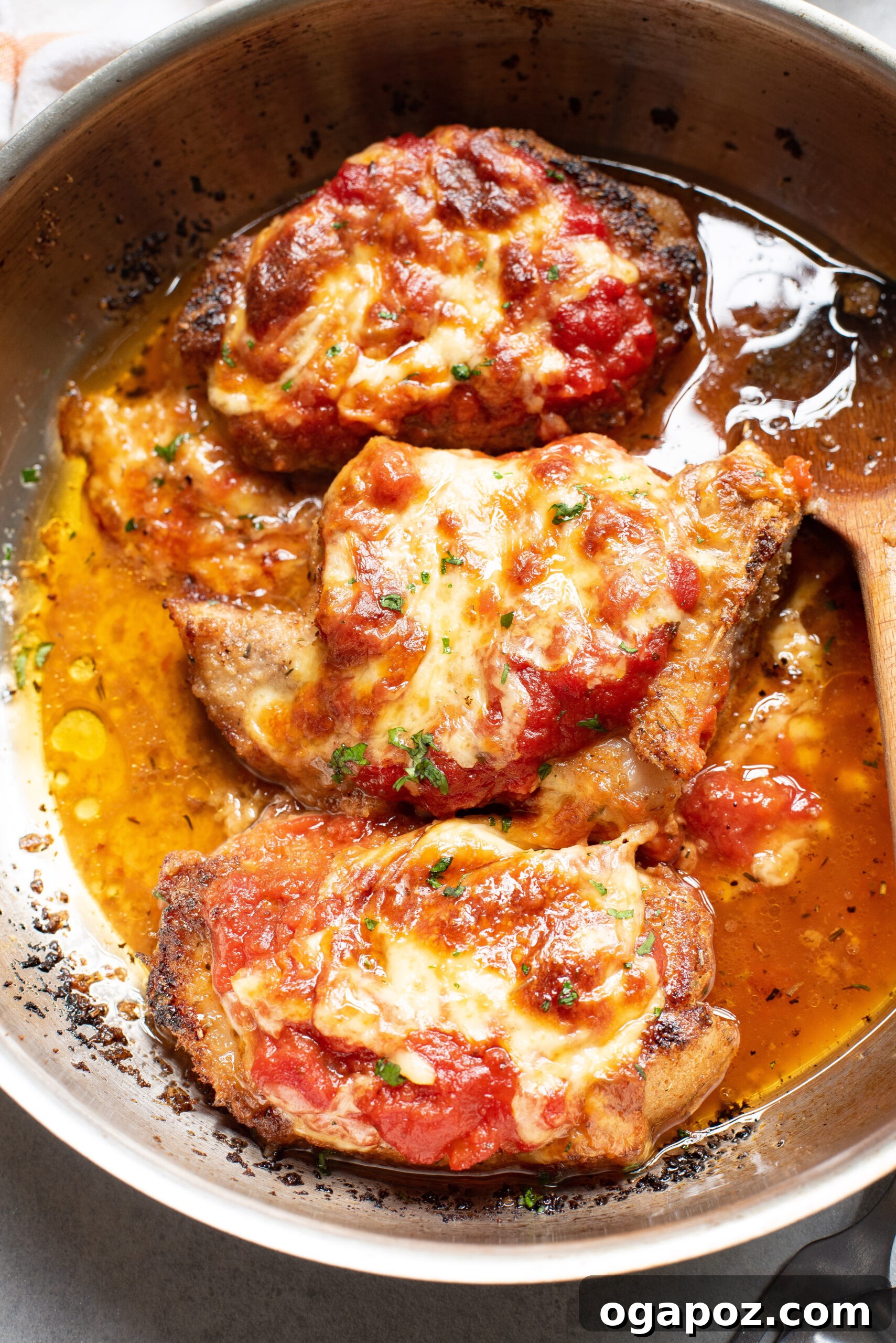 Crispy Parmesan Pork Chops 4 A close-up view of Parmesan Crusted Pork Chops being seared in a hot skillet, showing the golden-brown crust.