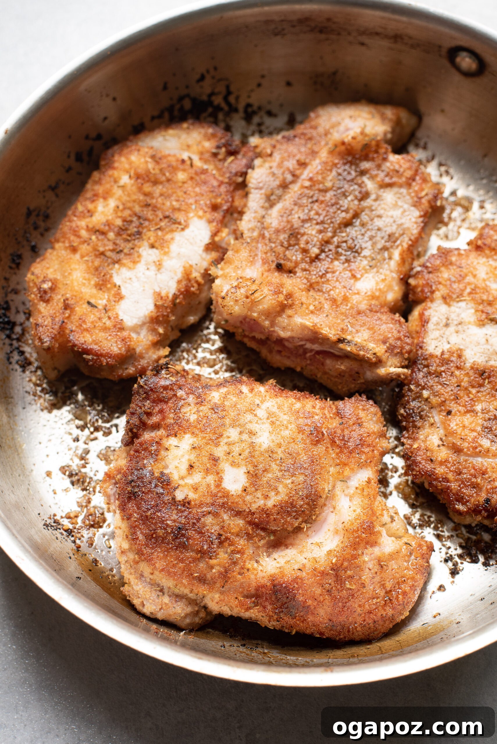 Crispy Parmesan Pork Chops 7 Parmesan Crusted Pork Chops with marinara sauce and shredded mozzarella cheese added, ready for the oven.