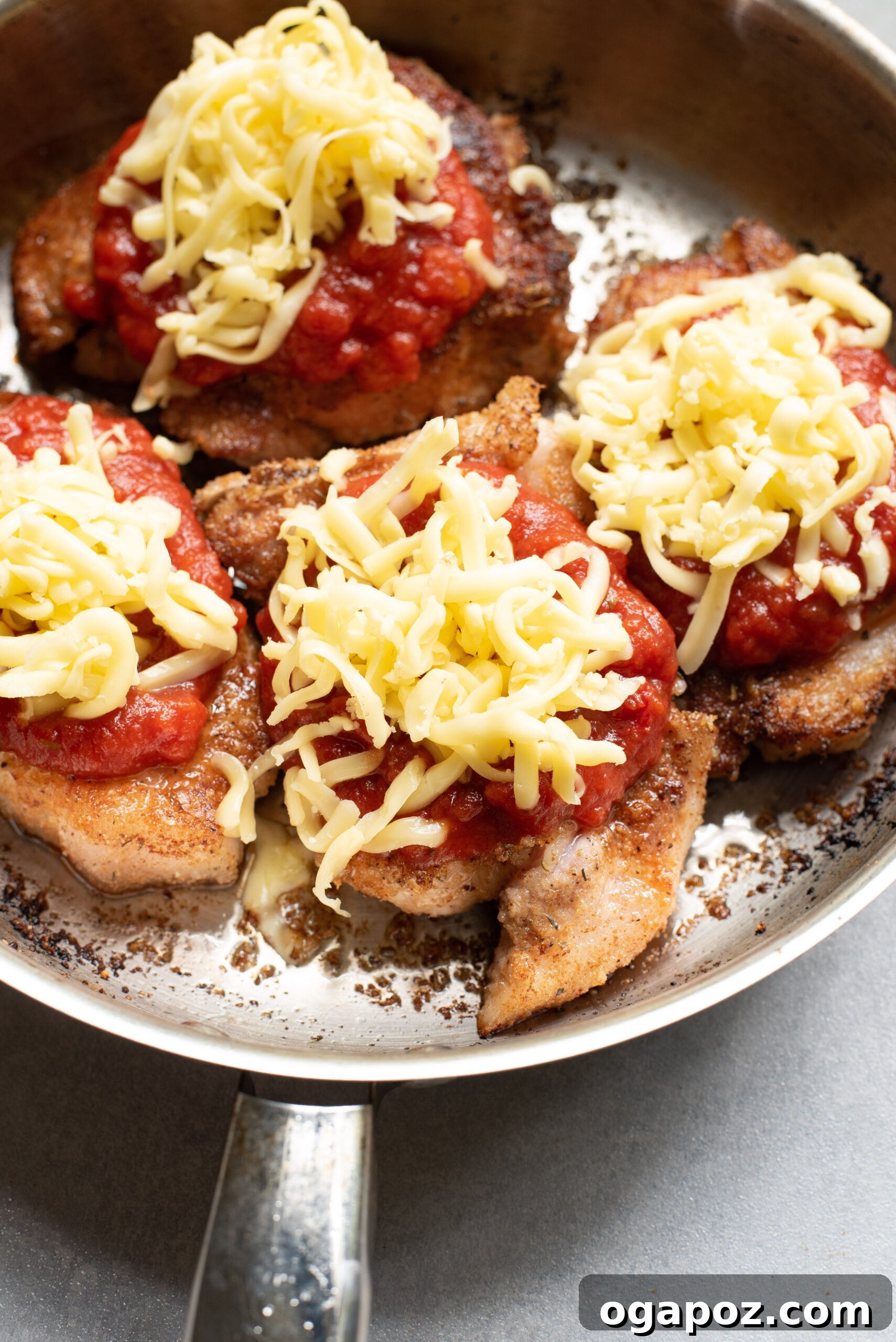 Crispy Parmesan Pork Chops 8 Baked Parmesan Crusted Pork Chops with melted shredded cheese and marinara, garnished with fresh parsley.