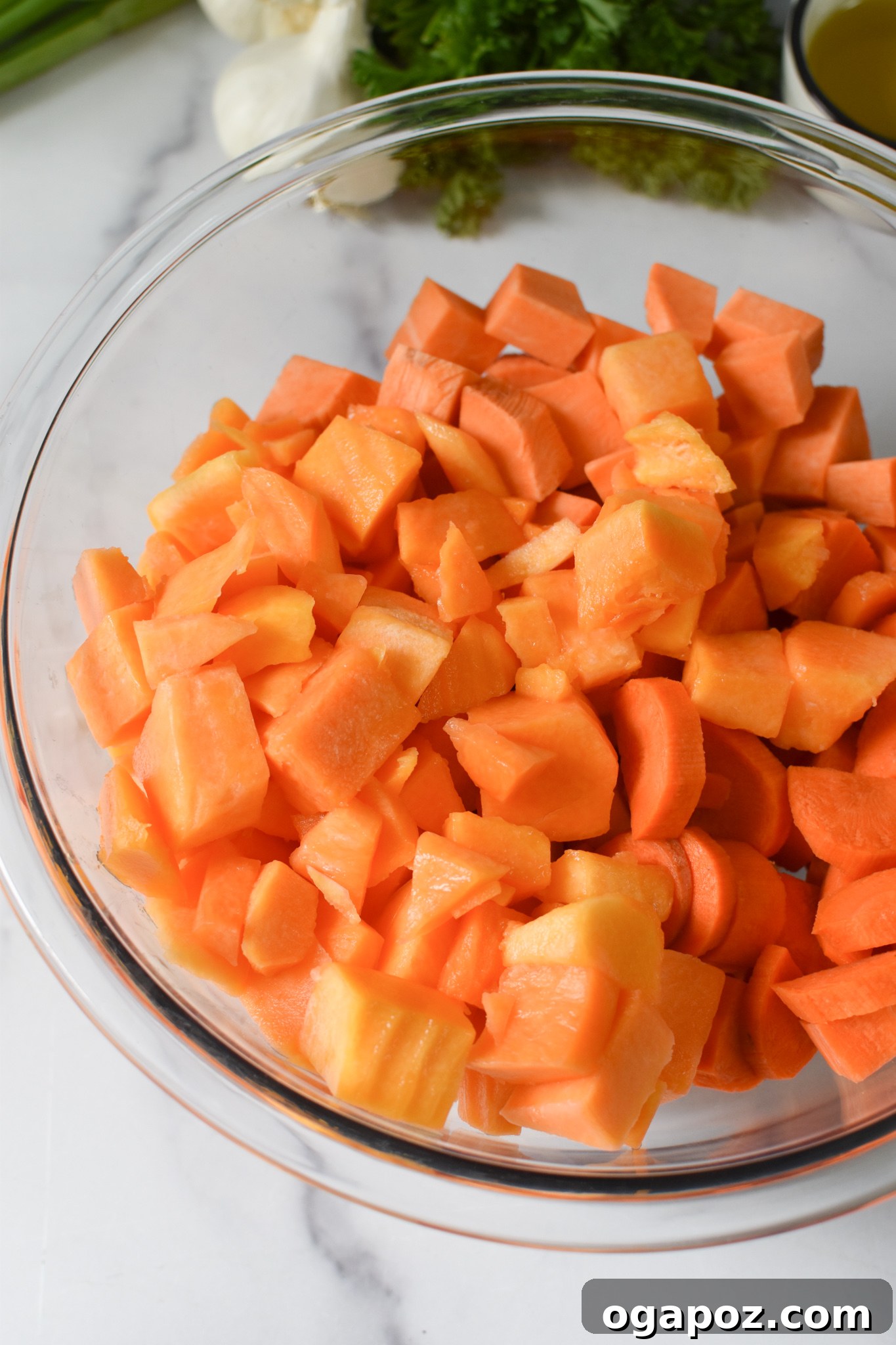 Golden Roasted Vegetable Medley 8 Cubed squash and other vegetables tossed with oil and seasoning in a bowl, ready for roasting.
