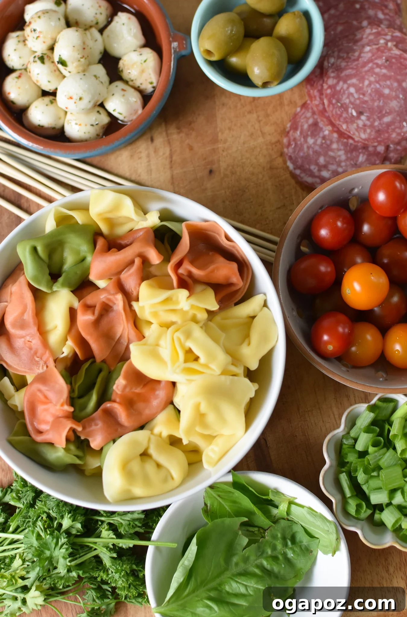 Flavorful Skewer Bites 4 A selection of fresh ingredients for Antipasto Skewers, including tomatoes, mozzarella, salami, and tortellini.