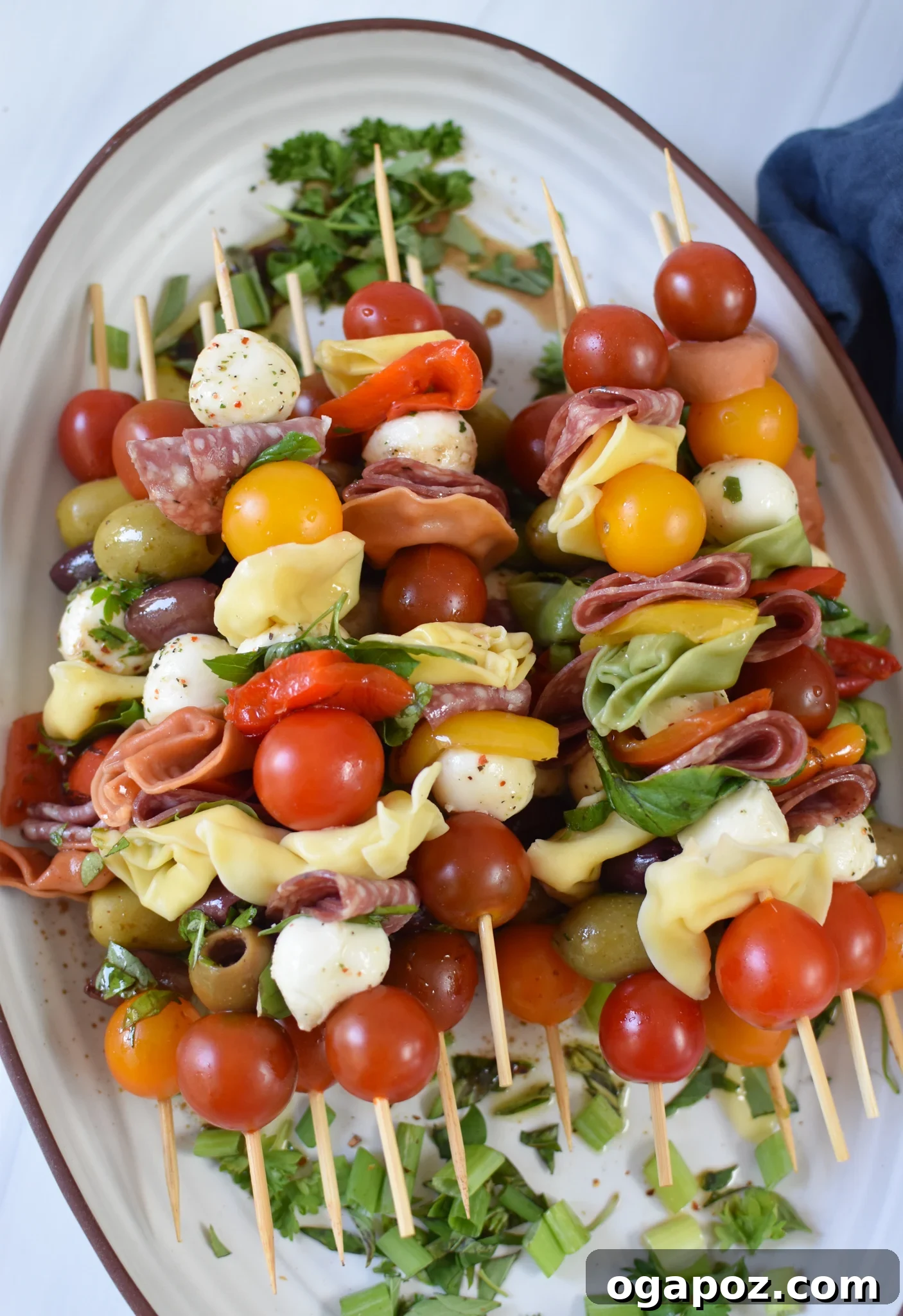 Flavorful Skewer Bites 5 Fully assembled Antipasto Skewers on a white platter, drizzled with balsamic glaze.