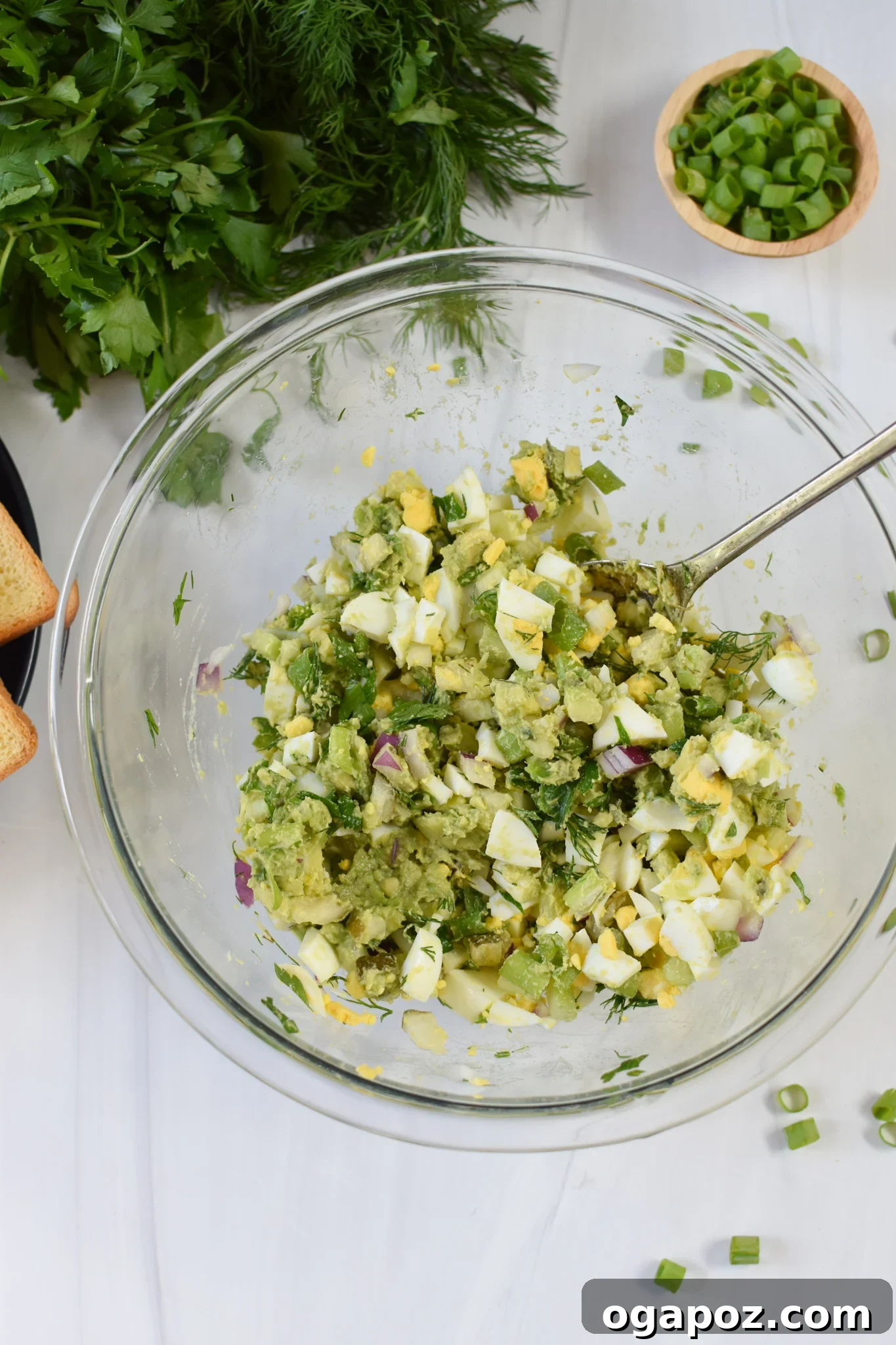 Green Goddess Egg Salad 6 Beautifully mixed Avocado Egg Salad in a glass bowl, ready to be served.