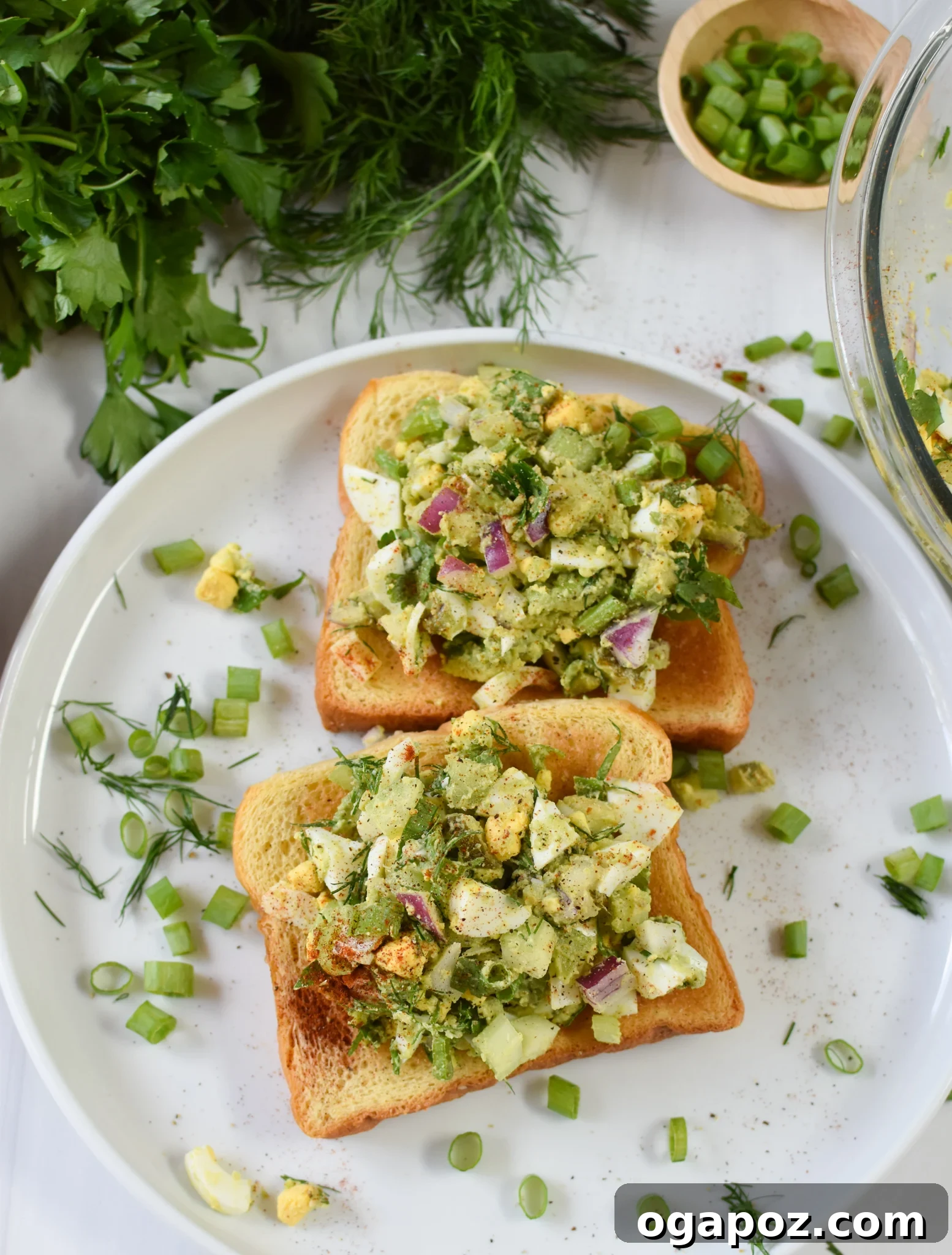 Green Goddess Egg Salad 7 Single serving of Avocado Egg Salad on a white plate, garnished with fresh herbs.