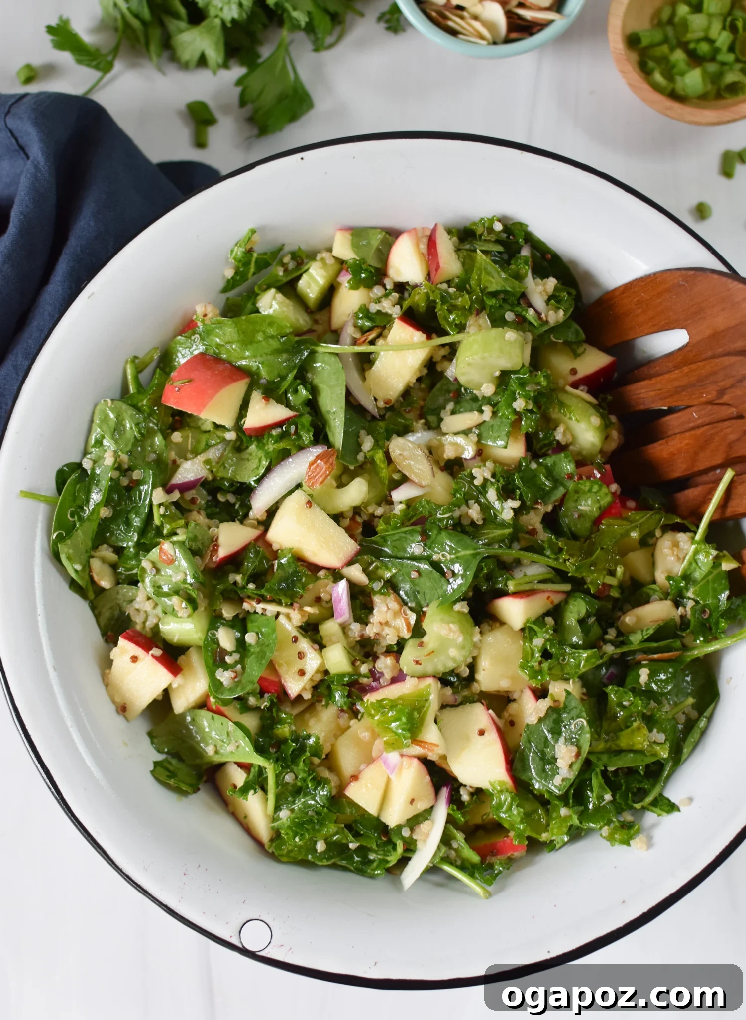 Vibrant Apple Kale Quinoa Medley 5 A beautifully presented Apple Kale Quinoa Salad in a large serving bowl, with wooden serving utensils ready for guests.