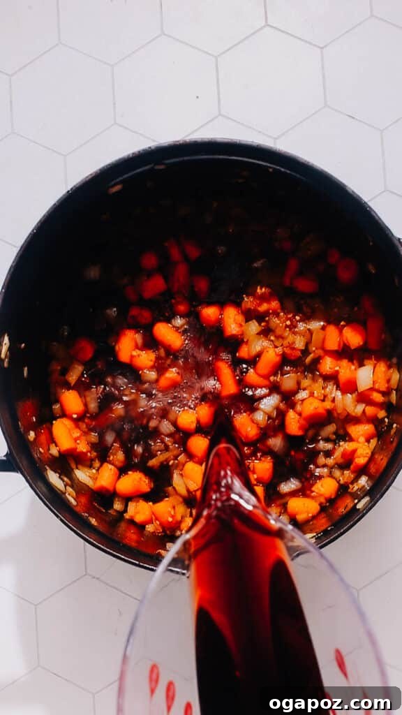 Hearty Dutch Oven Beef Feast 6 Deglazing the pot with red wine to release browned bits.