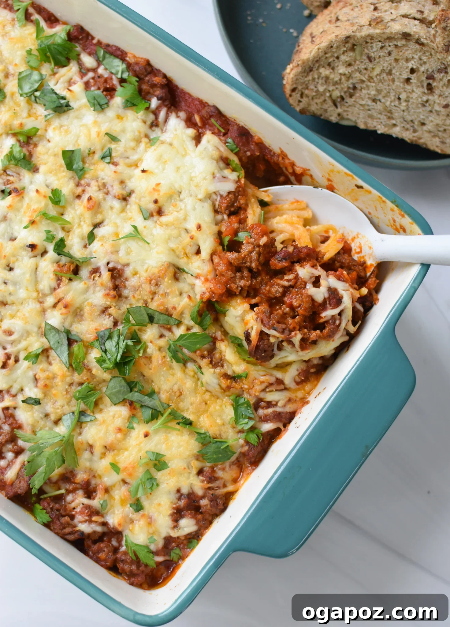Hearty Baked Spaghetti Casserole 4 A fork taking a scoop of Spaghetti Pie, showing the gooey cheese and rich meat sauce.