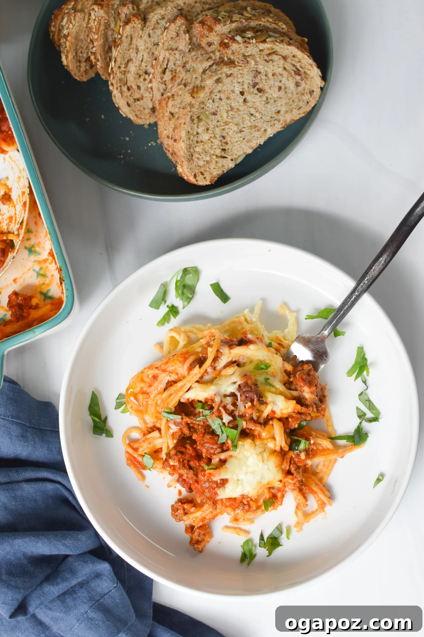 Hearty Baked Spaghetti Casserole 5 A serving of Spaghetti Pie with a fork, showing the distinct layers of pasta, cheese, and meat sauce.
