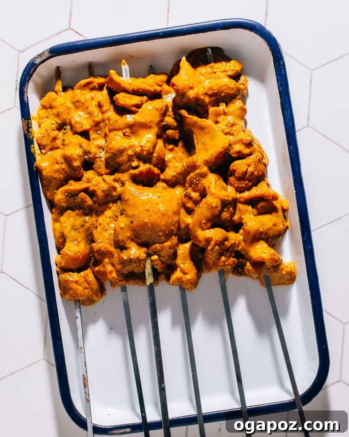 Irresistible Thai Satay Skewers 5 Chicken strips marinating in a flavorful Thai sauce in a bowl.