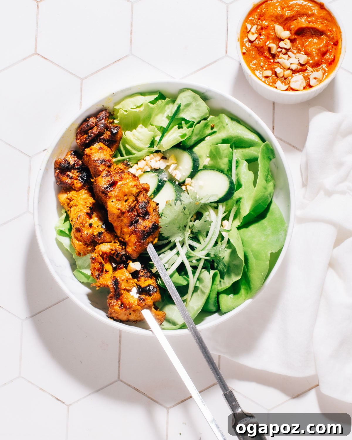 Irresistible Thai Satay Skewers 7 Thai Satay chicken skewers served elegantly atop a fresh green salad in a bowl.