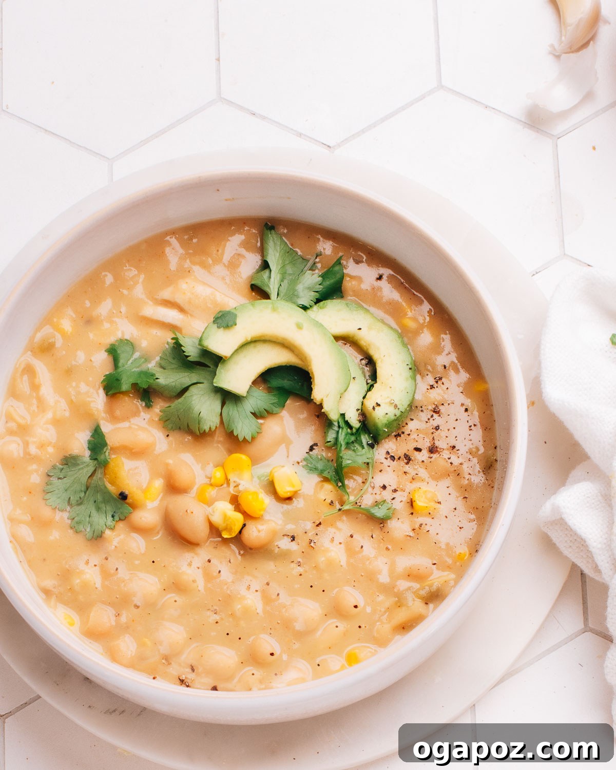 Wholesome Turkey and White Bean Chili 2 A bowl of creamy White Bean Turkey Chili generously topped with fresh corn kernels, vibrant cilantro, and creamy avocado slices, ready to be enjoyed.