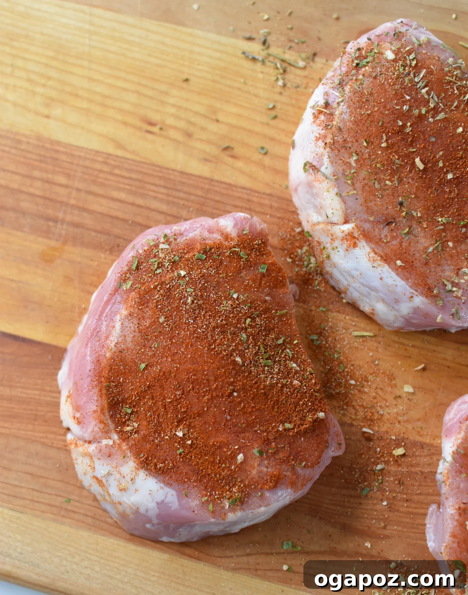 Effortless Air Fryer Boneless Pork Chops 5 Boneless pork chops generously seasoned with a spice rub and being brushed with homemade BBQ sauce.