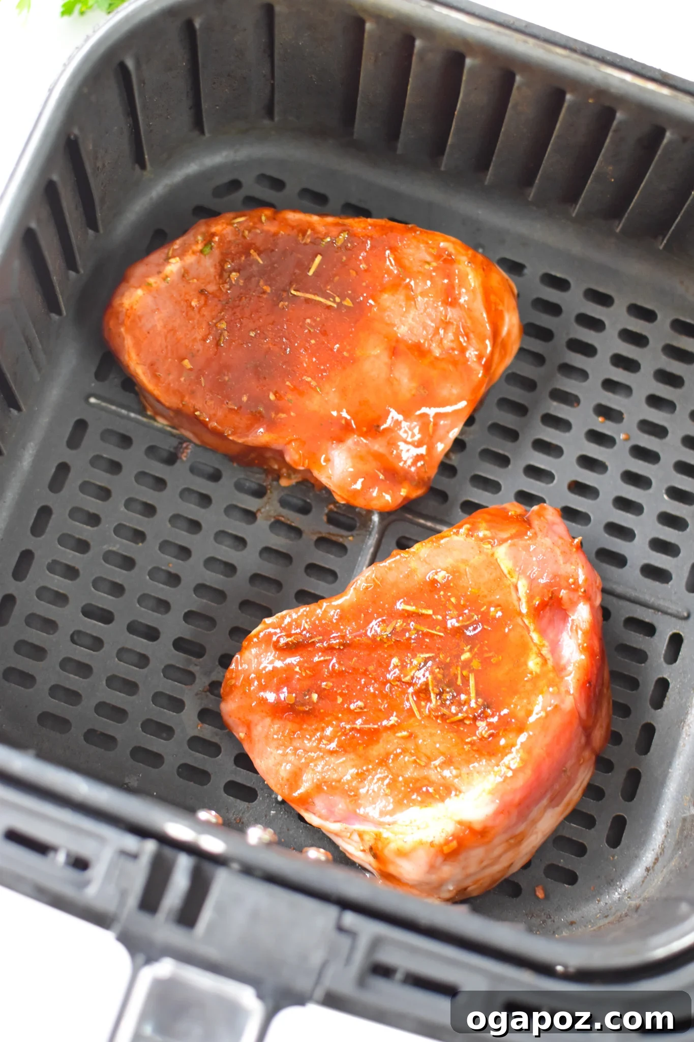 Effortless Air Fryer Boneless Pork Chops 6 Boneless pork chops cooking evenly in a single layer within the air fryer basket.