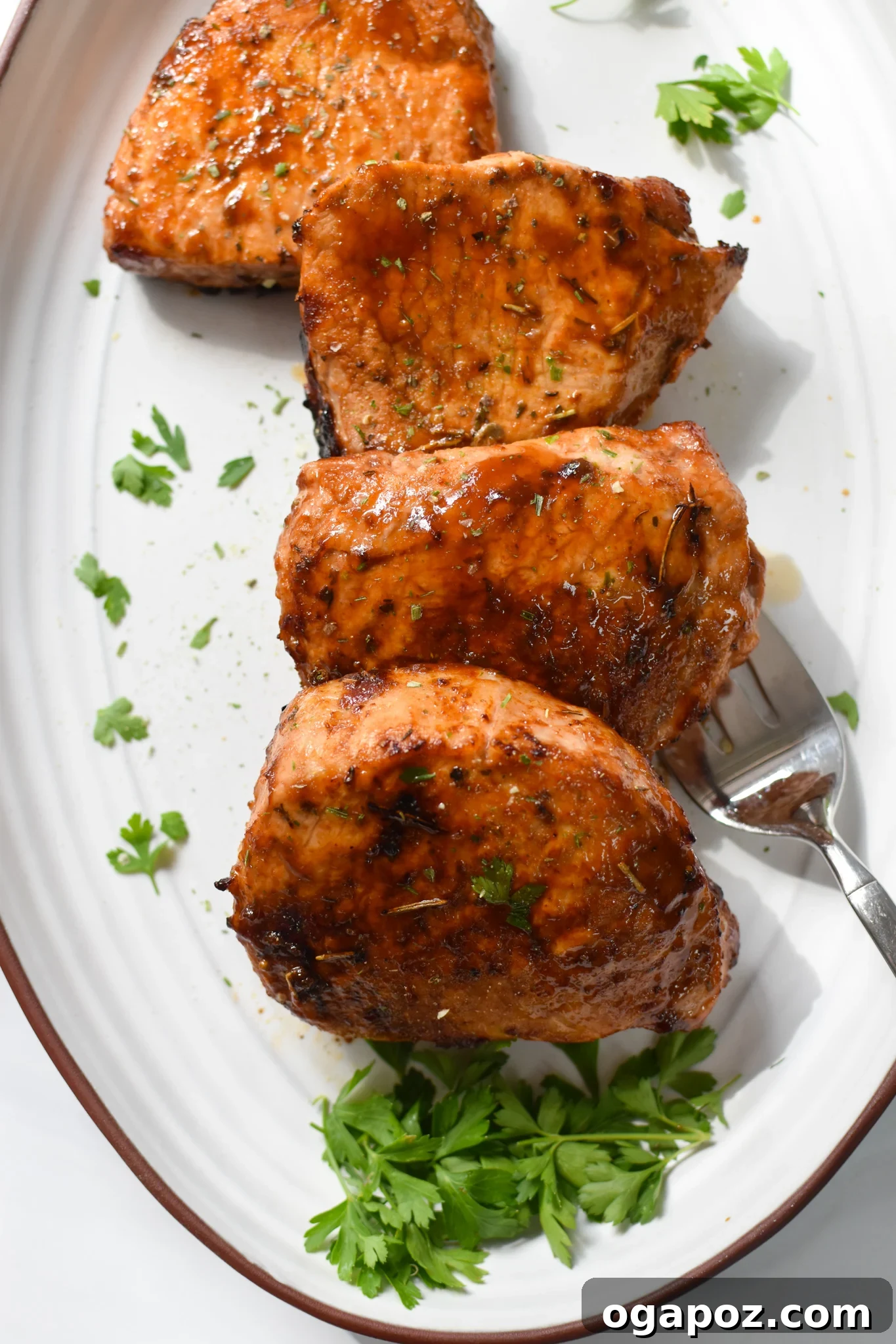 Effortless Air Fryer Boneless Pork Chops 7 Perfectly cooked Air Fryer Boneless Pork Chops presented on a clean white plate, ready for serving.