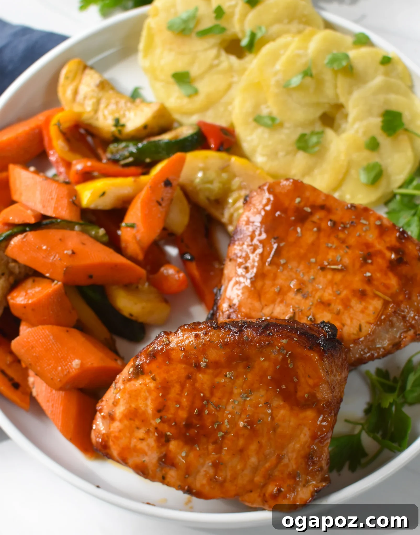 Effortless Air Fryer Boneless Pork Chops 8 Plated Air Fryer Boneless Pork Chops alongside roasted vegetables and potatoes, showcasing a complete meal.