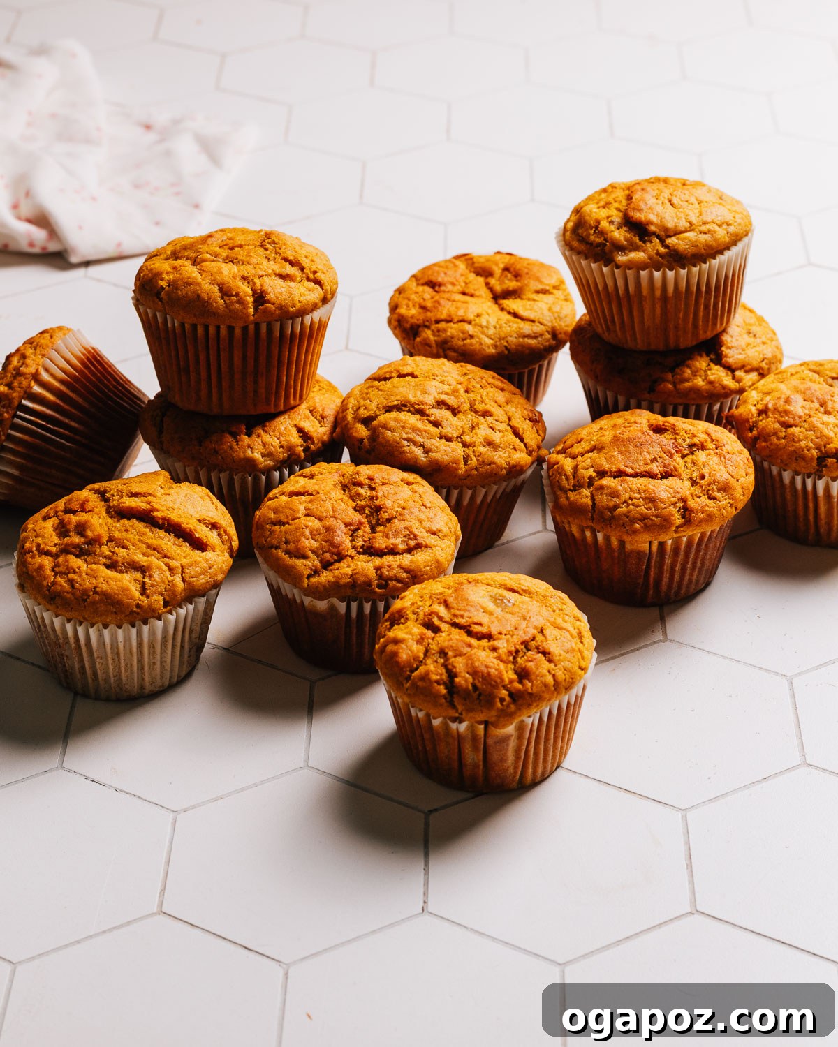 Spiced Pumpkin Banana Muffins 2 Delicious, golden-brown Pumpkin Banana Muffins arranged on a white countertop, ready to be enjoyed.