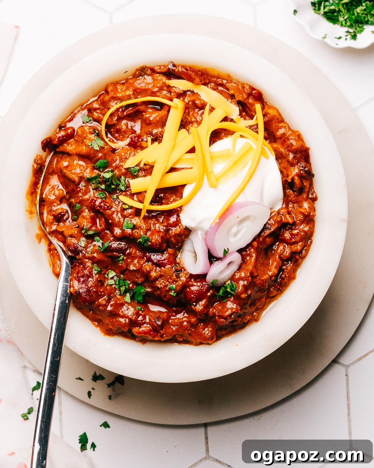 A steaming bowl of Instant Pot Chili, garnished with fresh herbs and a dollop of sour cream.